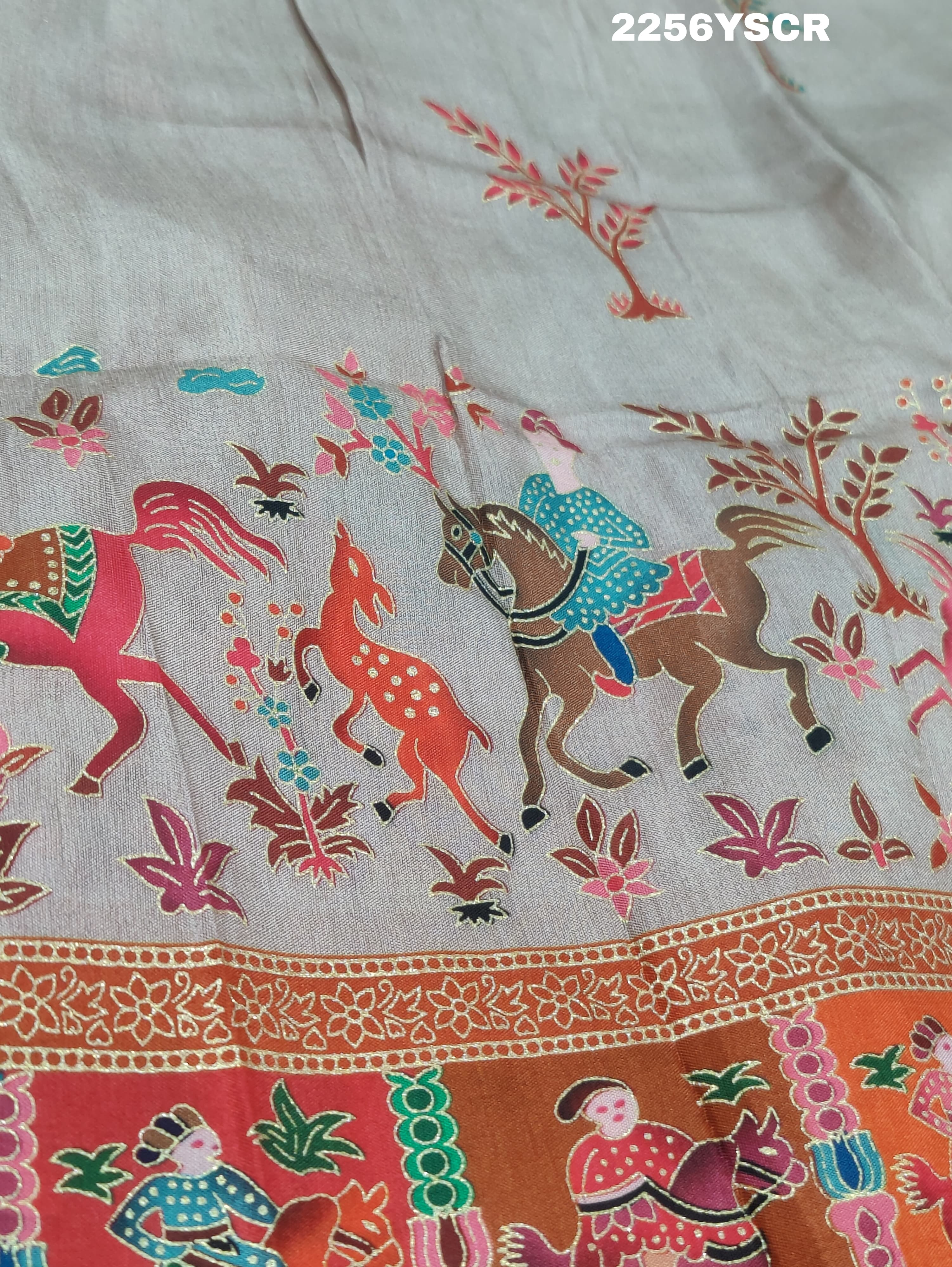 A cotton silk saree with a kalamkari style foil print design in multiple colors including cream, red, and green.