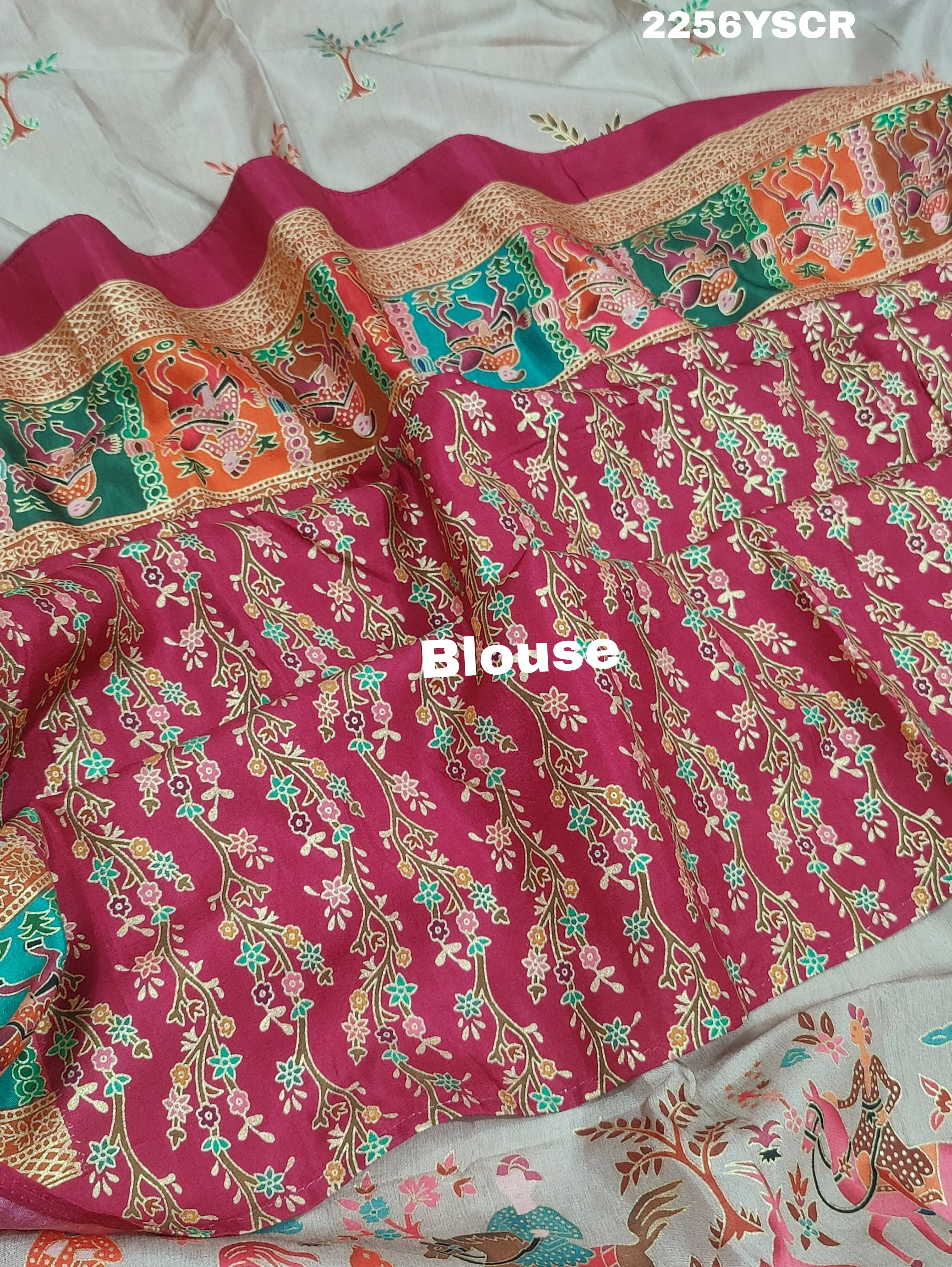 A cotton silk saree with a kalamkari style foil print design in multiple colors including cream, red, and green.