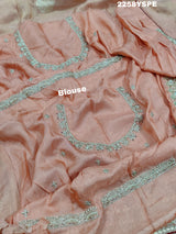 A peach-colored Banarasi silk saree with Bollywood-style embellishments including sequins and gotapatti work,