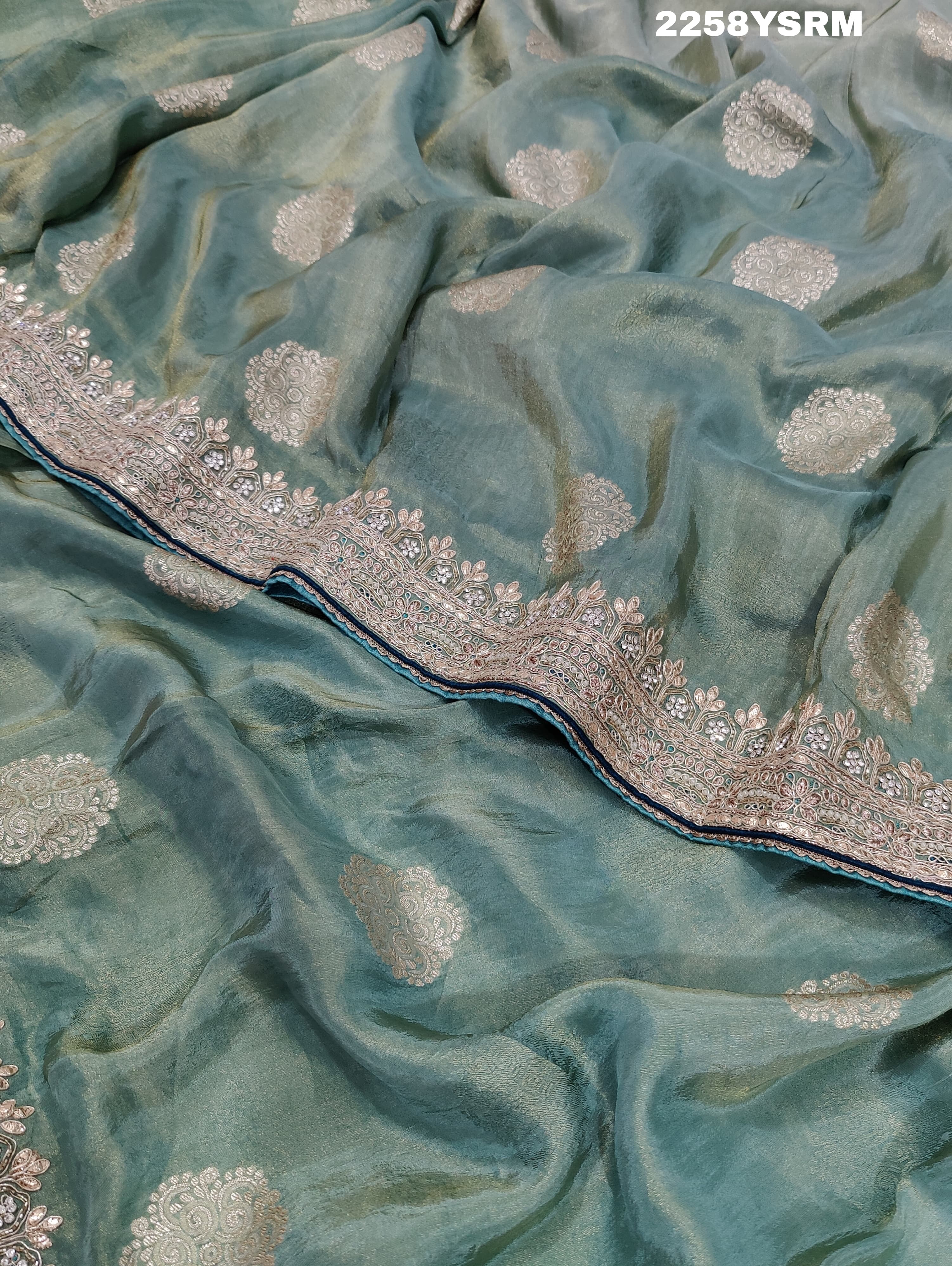A sea green Banarasi silk saree with Bollywood style embellishments including sequins and gotapatti work