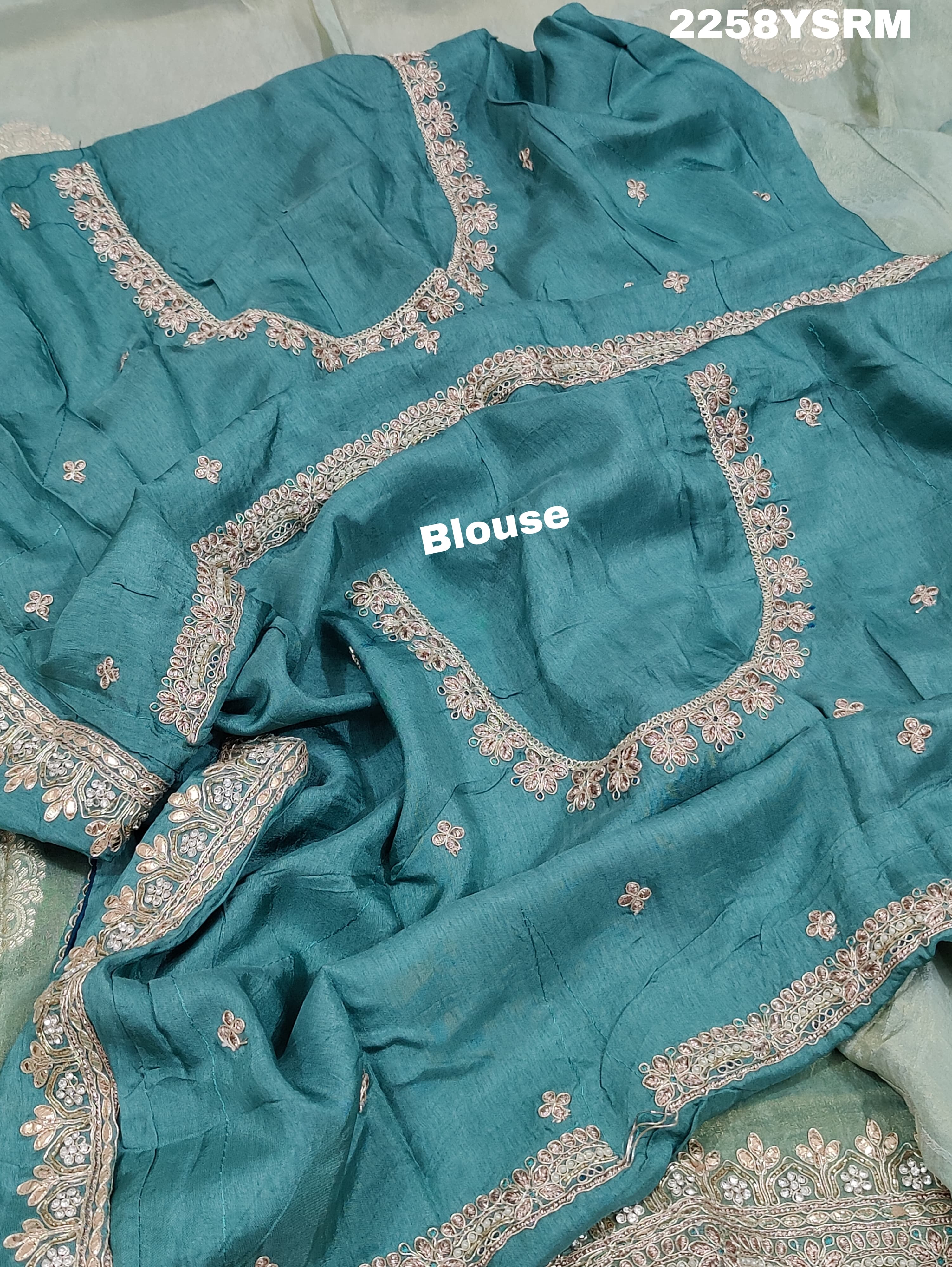 A sea green Banarasi silk saree with Bollywood style embellishments including sequins and gotapatti work