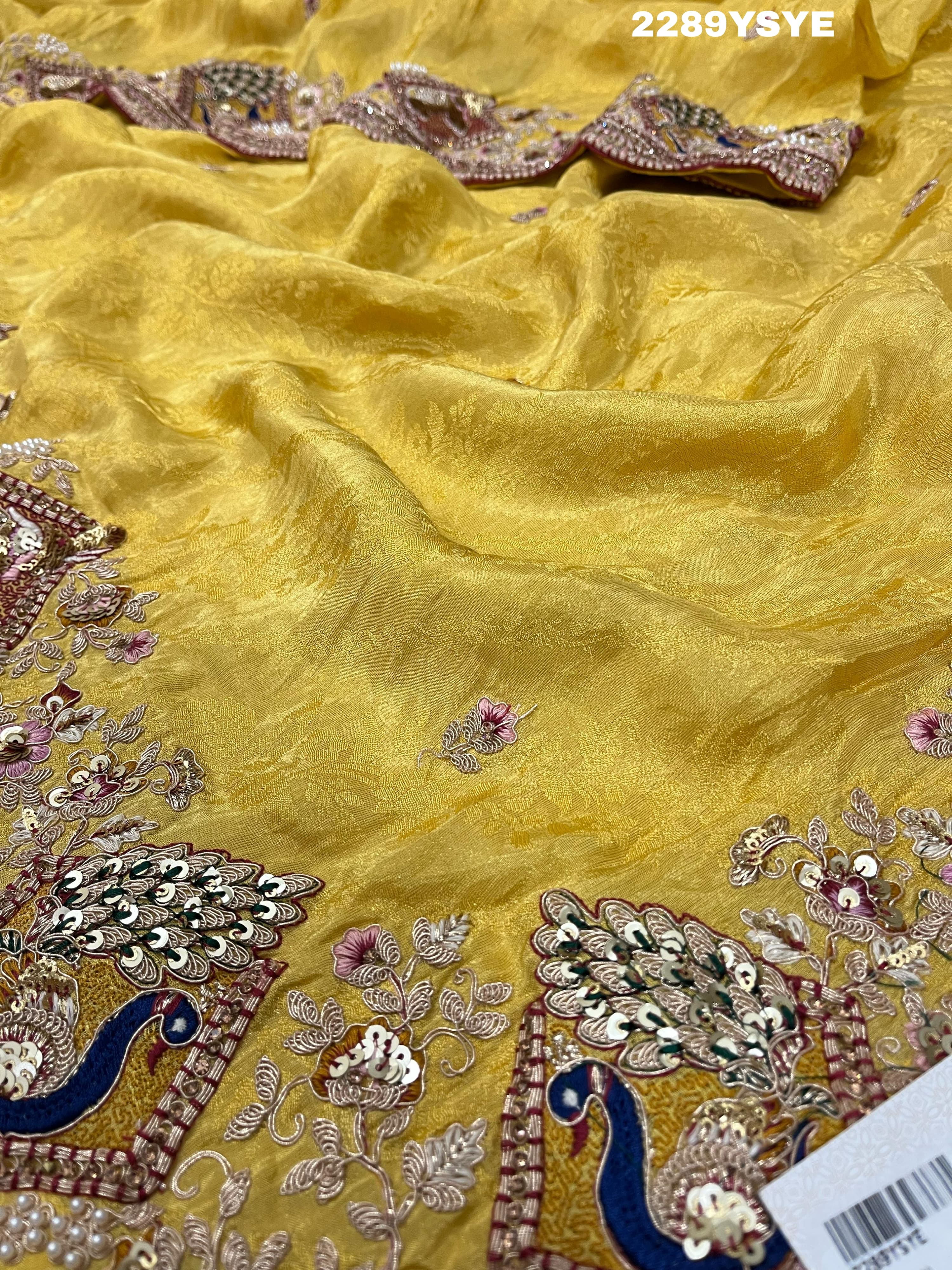 A yellow Banarasi silk saree with Bollywood style embellishments including sequins and a distinctive pattern.