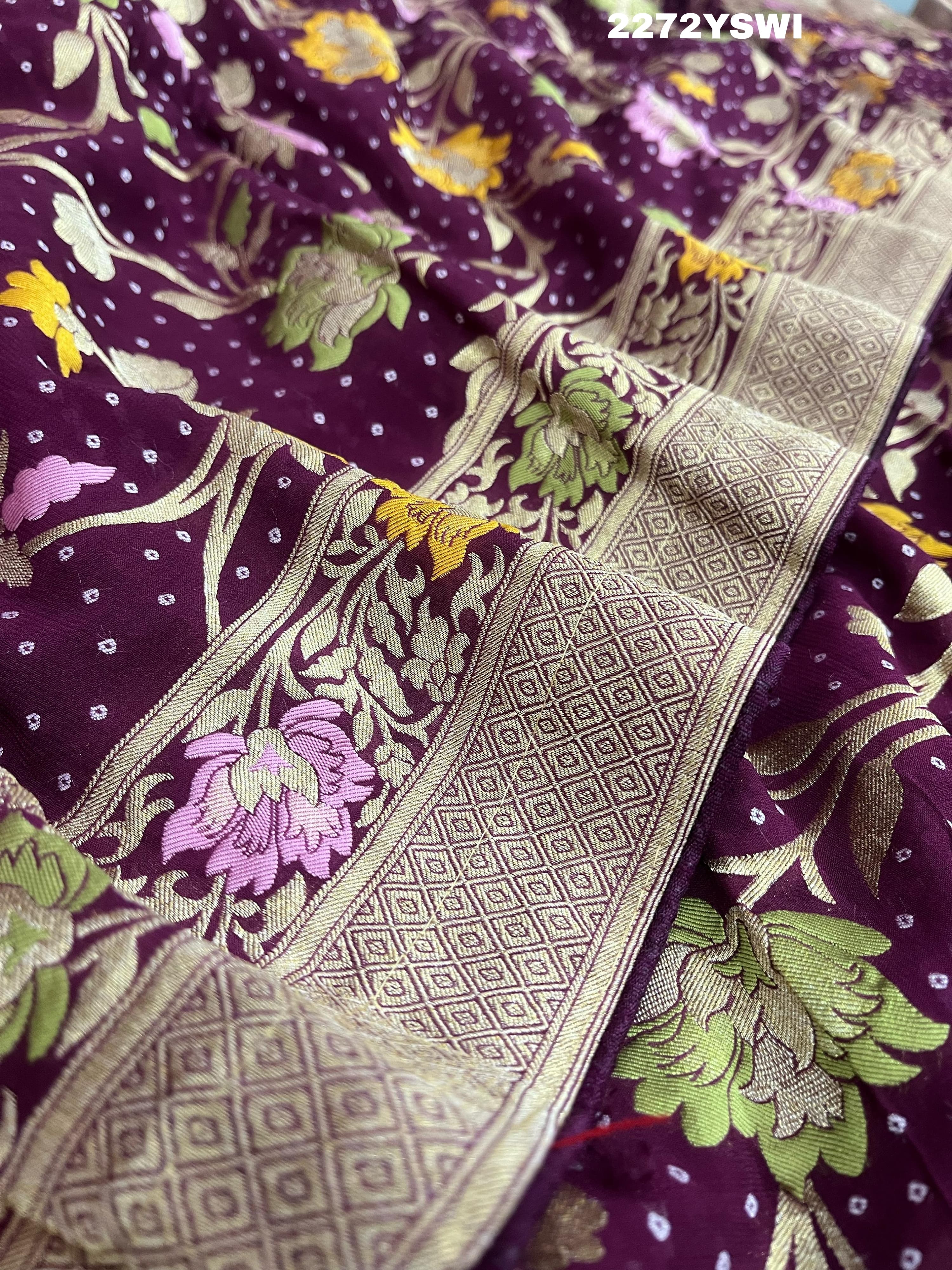 A purple georgette saree with a Meenakari weaving pattern, showing detailed floral designs and a border.