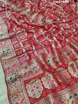 A red and gold georgette bandhani style saree with meenakari weaving,