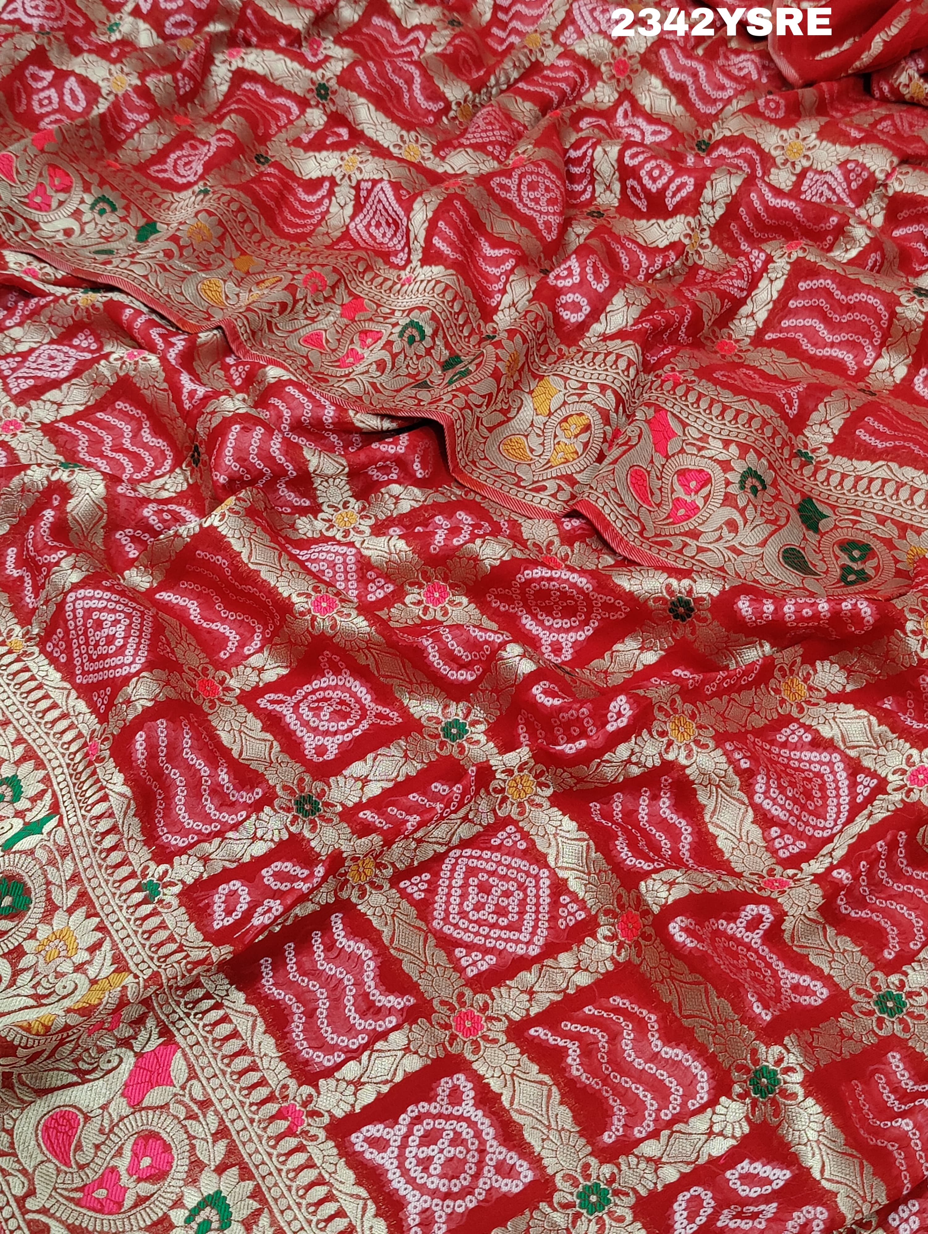 A red and gold georgette bandhani style saree with meenakari weaving,