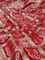 A red and gold georgette bandhani style saree with meenakari weaving,
