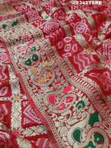 A red and gold georgette bandhani style saree with meenakari weaving,