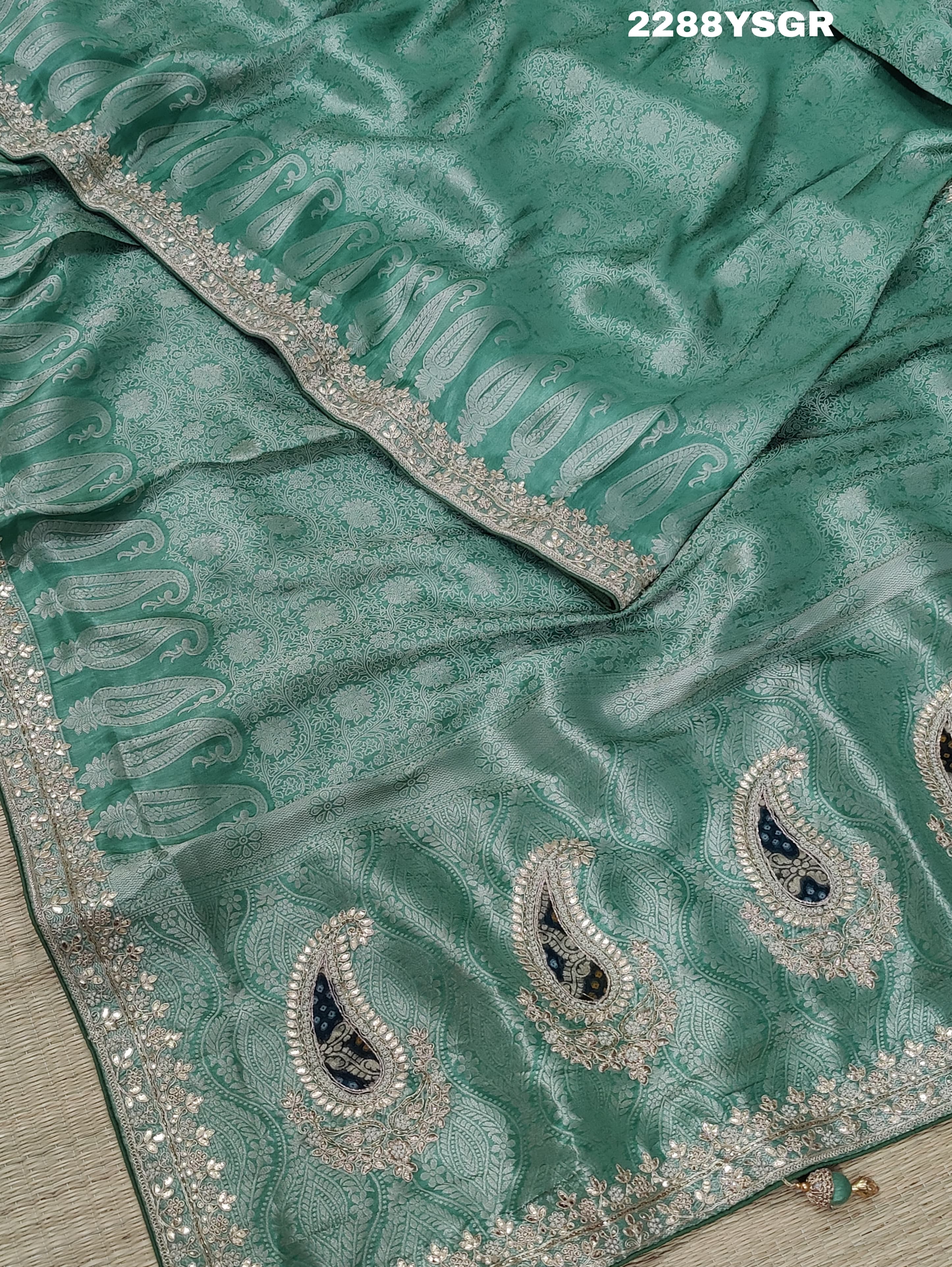 A green Banarsi silk saree with Bollywood style embellishments including sequins and gotapatti work