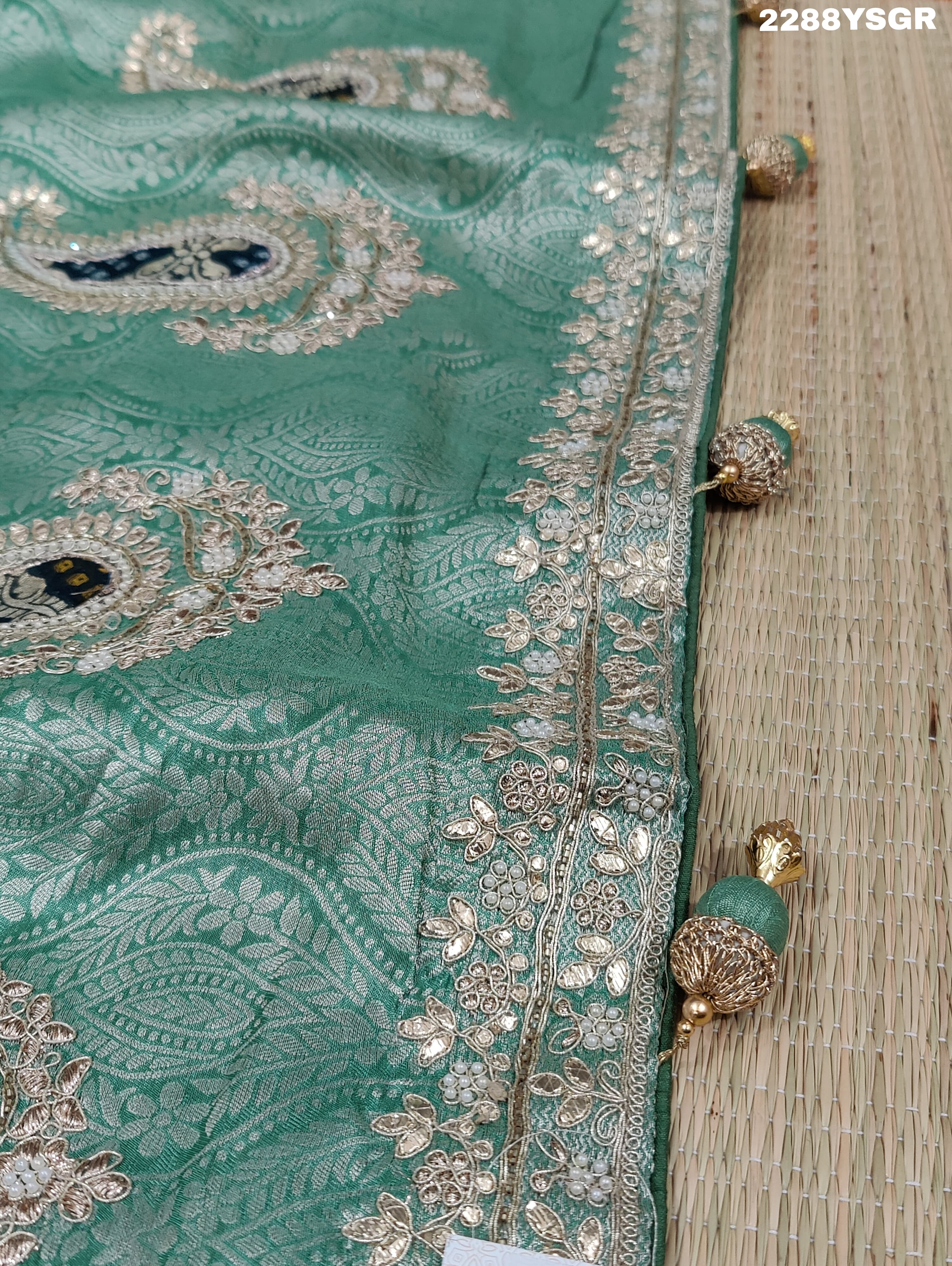 A green Banarsi silk saree with Bollywood style embellishments including sequins and gotapatti work