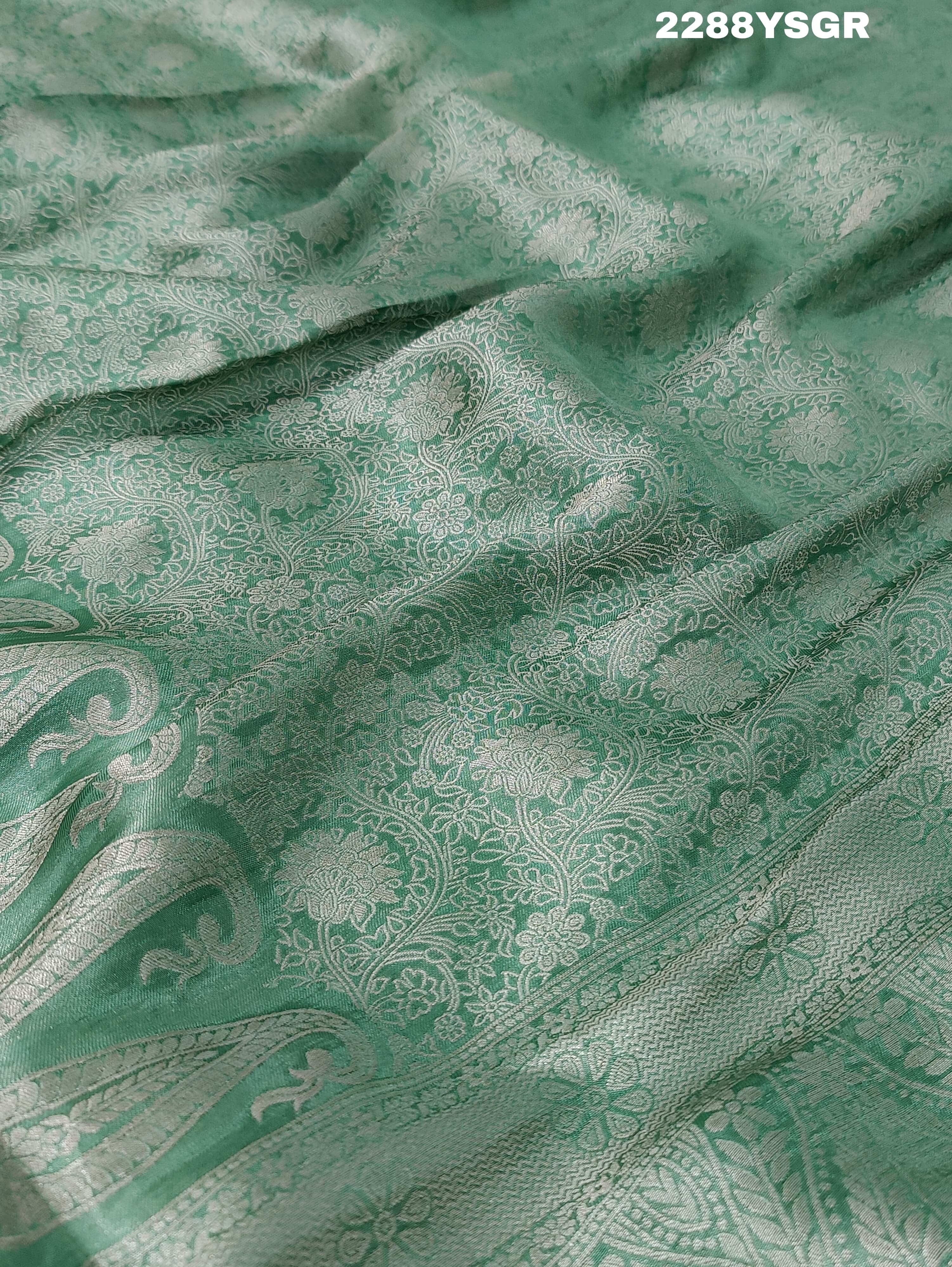 A green Banarsi silk saree with Bollywood style embellishments including sequins and gotapatti work