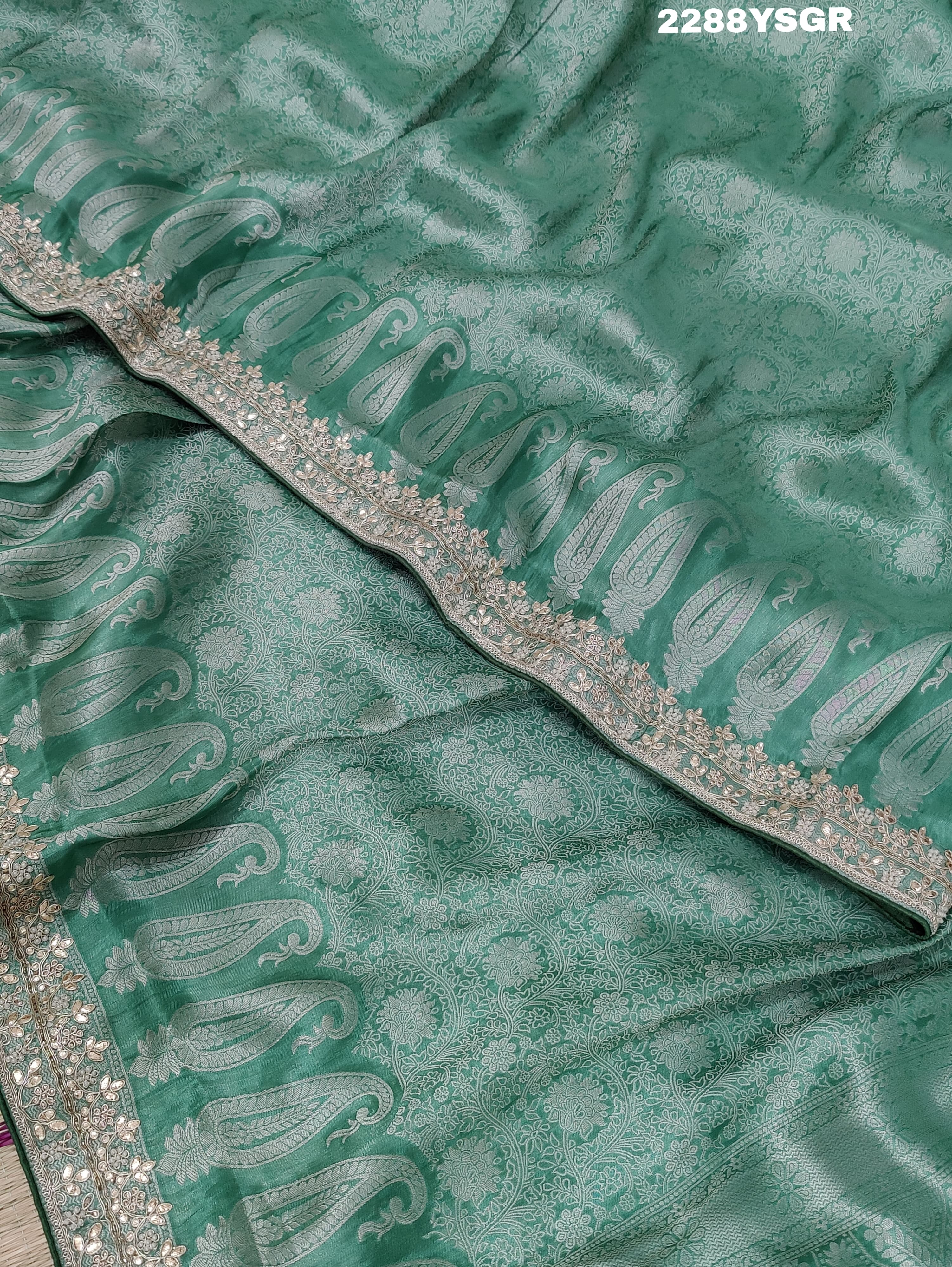 A green Banarsi silk saree with Bollywood style embellishments including sequins and gotapatti work