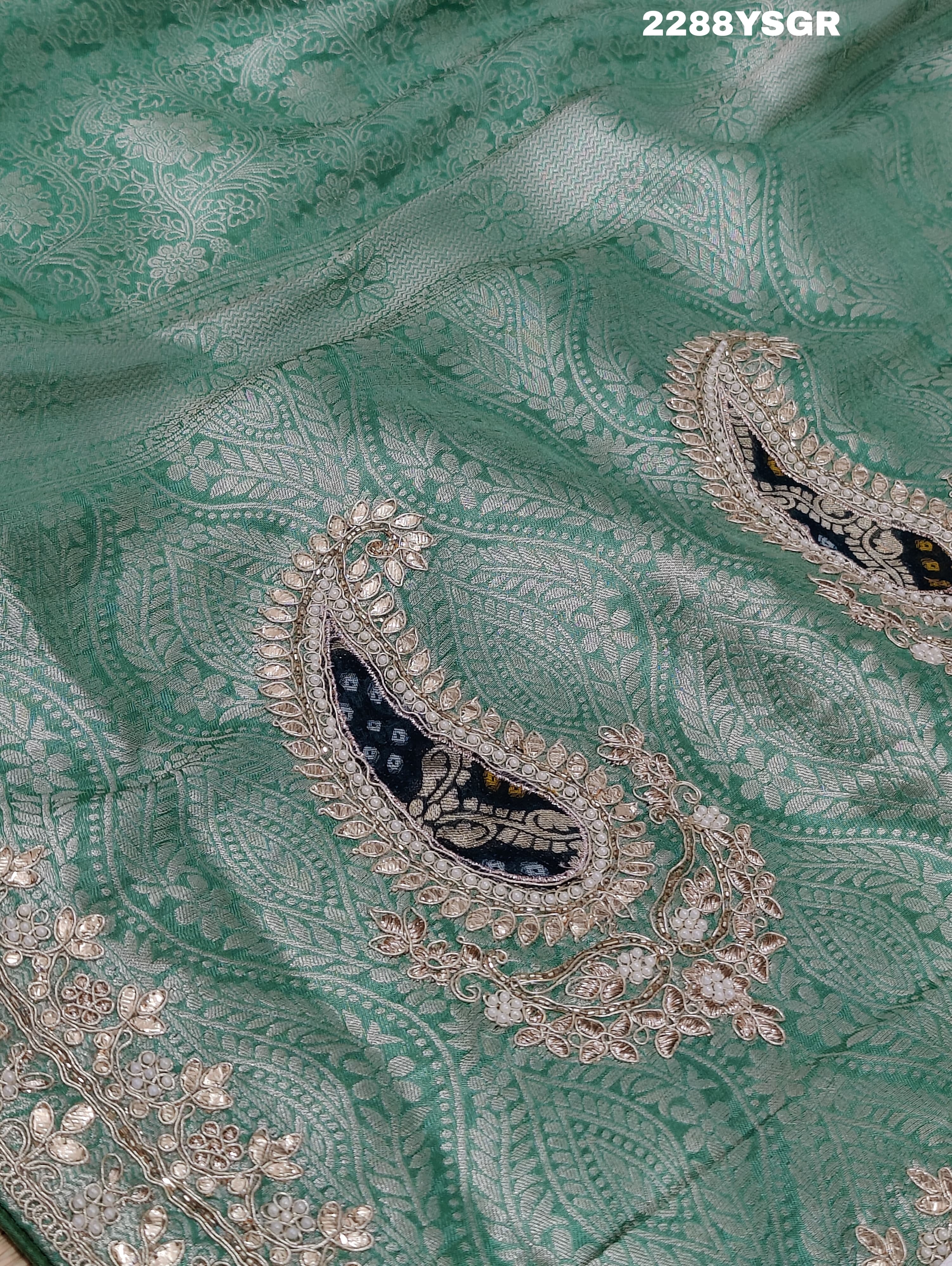 A green Banarsi silk saree with Bollywood style embellishments including sequins and gotapatti work