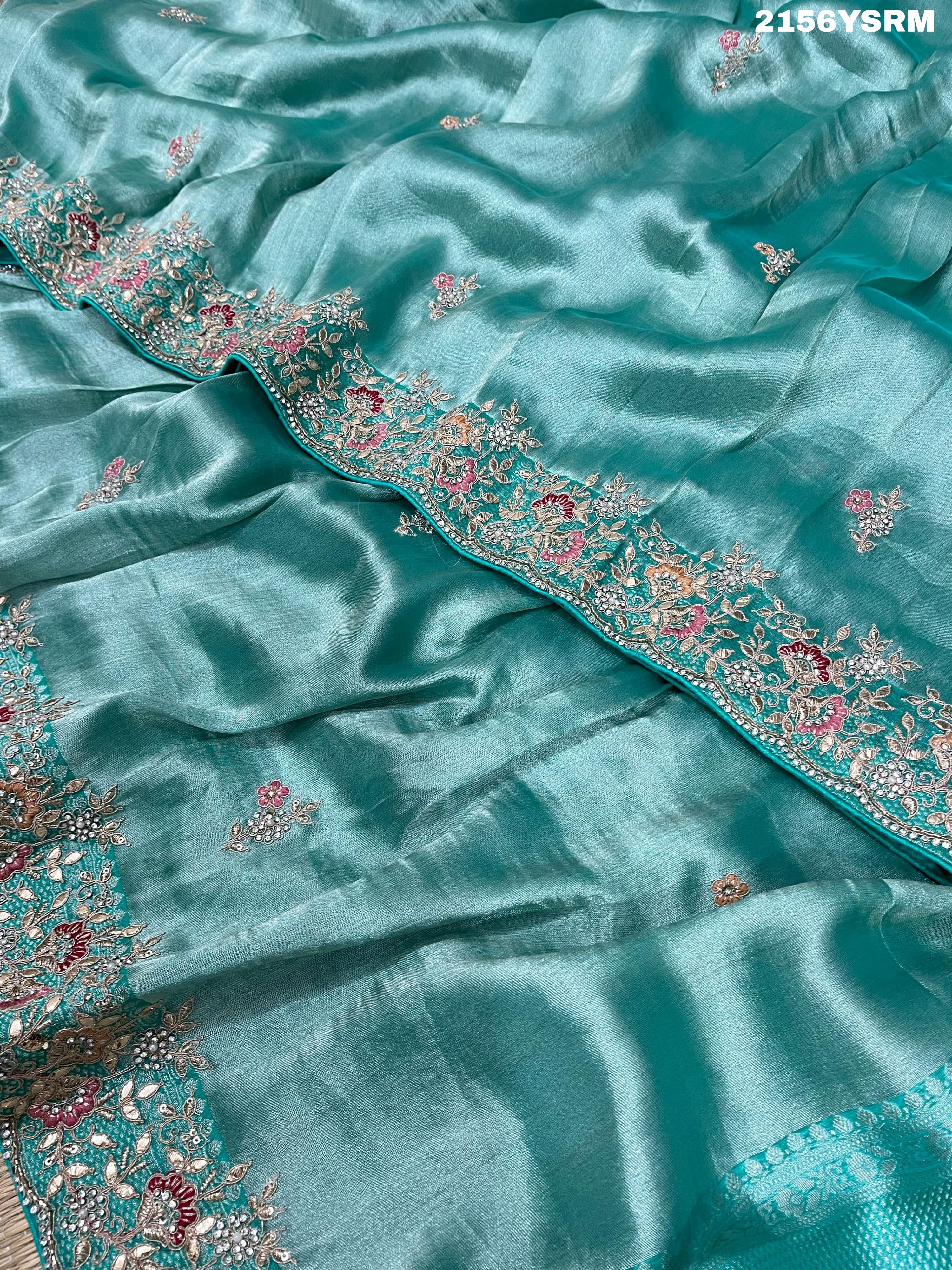 A sea green tissue silk saree with sequence embroidery work in a Bollywood style pattern.