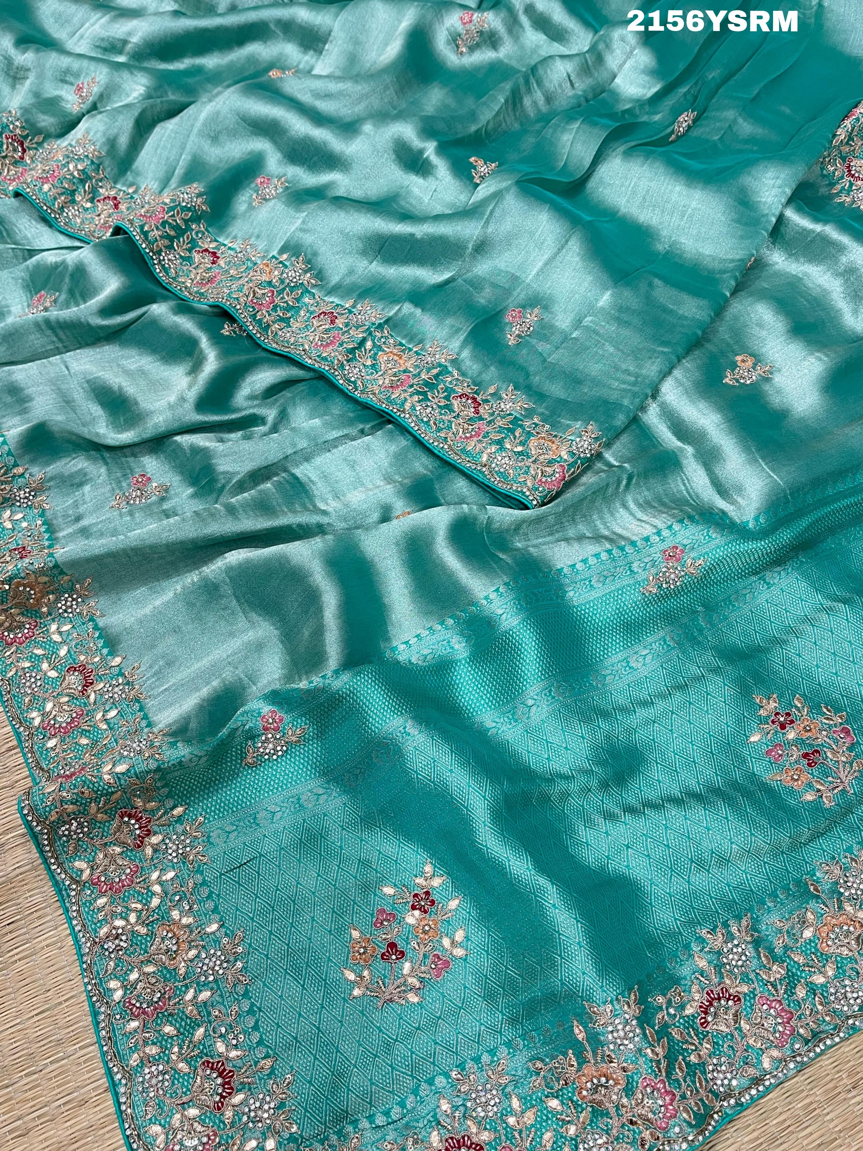A sea green tissue silk saree with sequence embroidery work in a Bollywood style pattern.