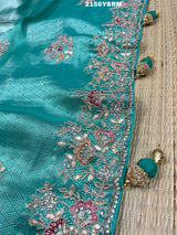 A sea green tissue silk saree with sequence embroidery work in a Bollywood style pattern.