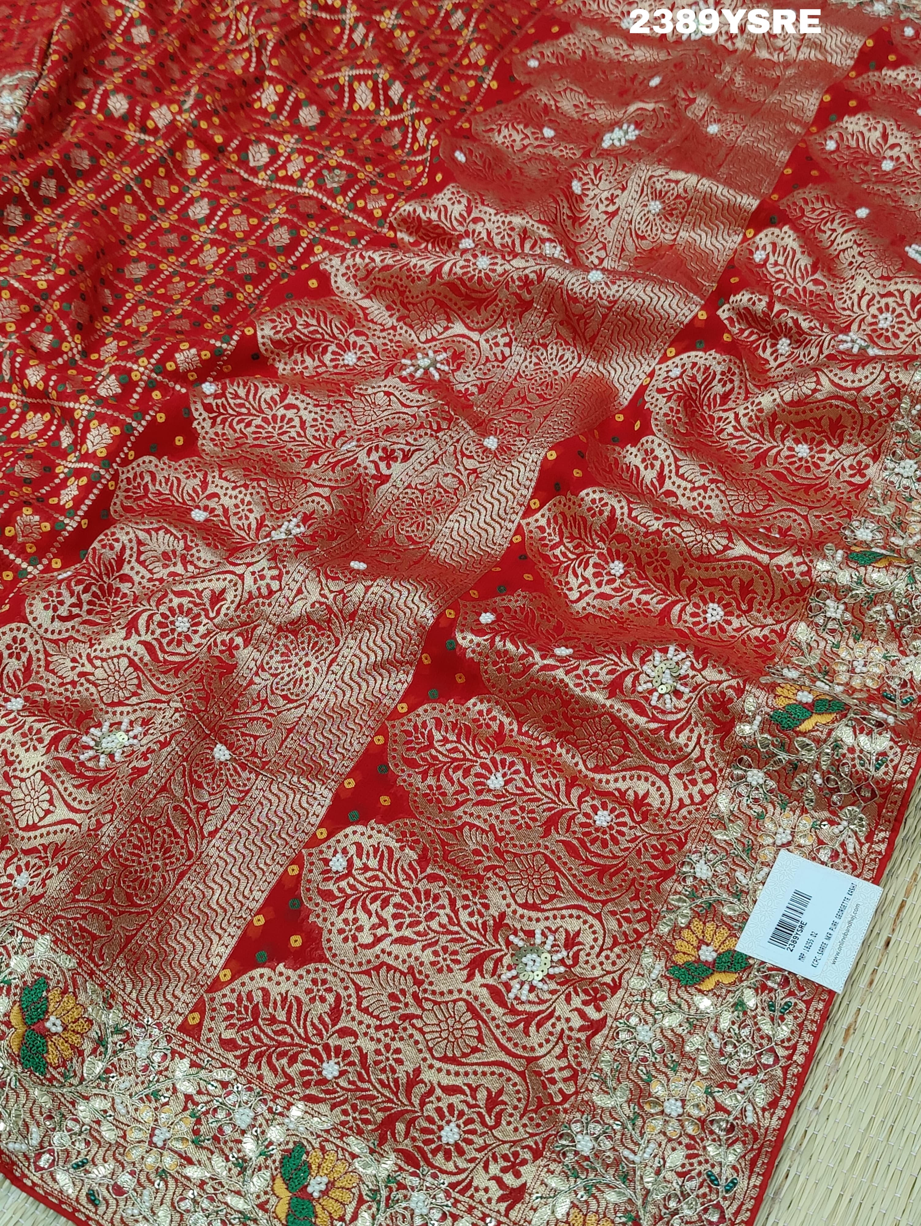 A red Banarasi style saree with gotapatti work, showcasing the detailed embroidery and pattern.