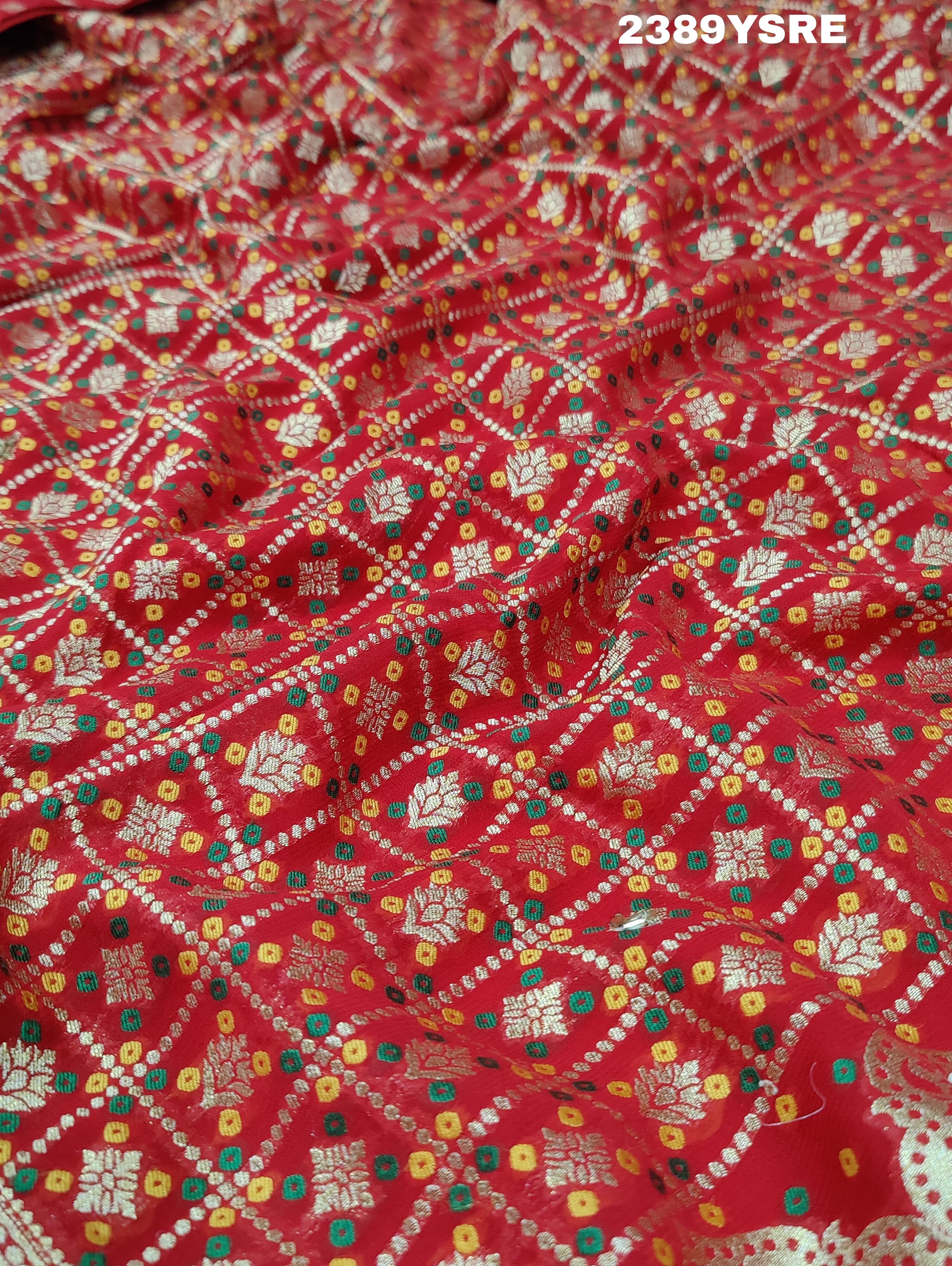 A red Banarasi style saree with gotapatti work, showcasing the detailed embroidery and pattern.