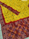 A yellow and red Dola silk saree with Zari weaving and a floral pattern,