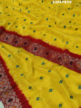 A yellow and red Dola silk saree with Zari weaving and a floral pattern,