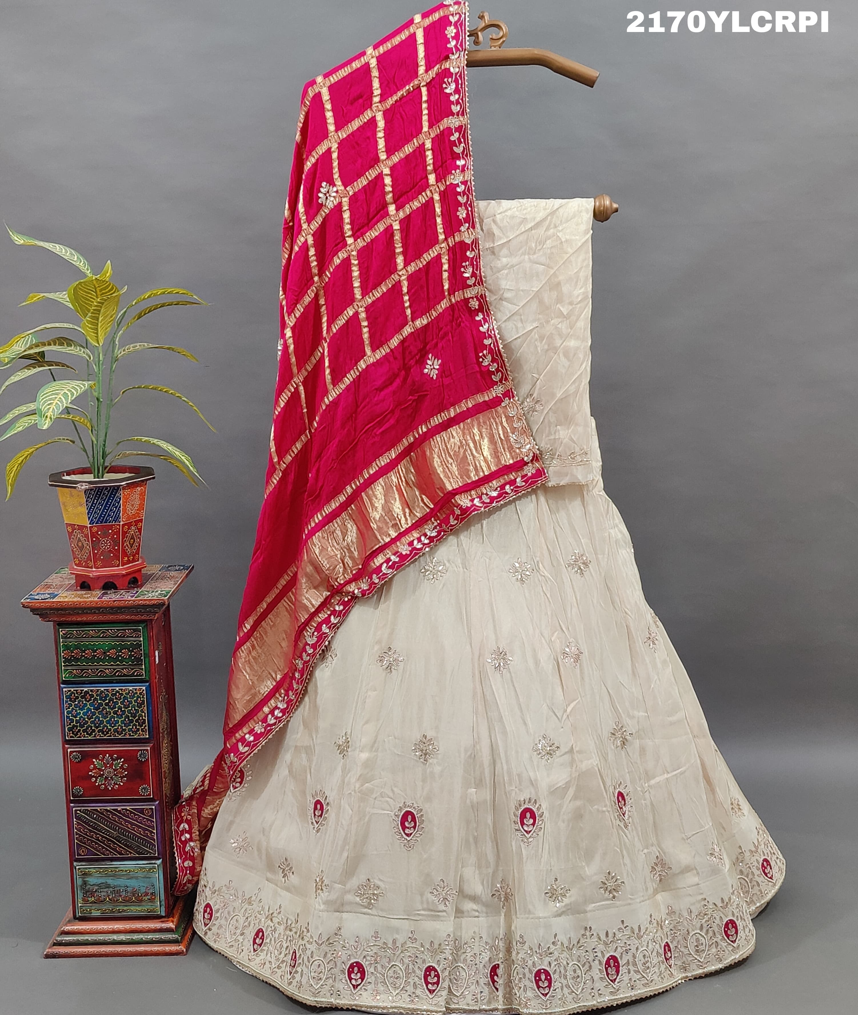 A cream-colored Lehenga with pink and gold embellishments