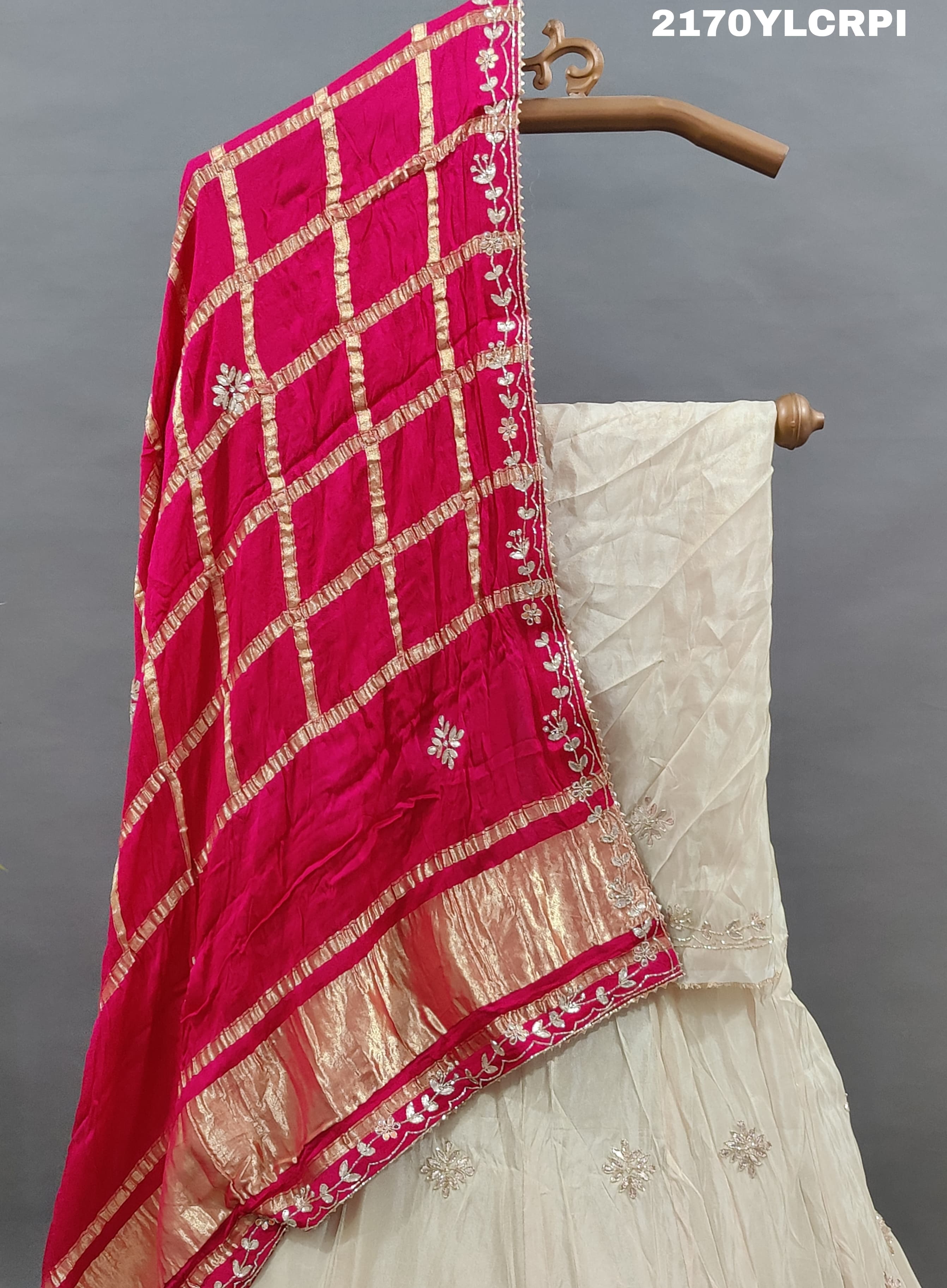 A cream-colored Lehenga with pink and gold embellishments