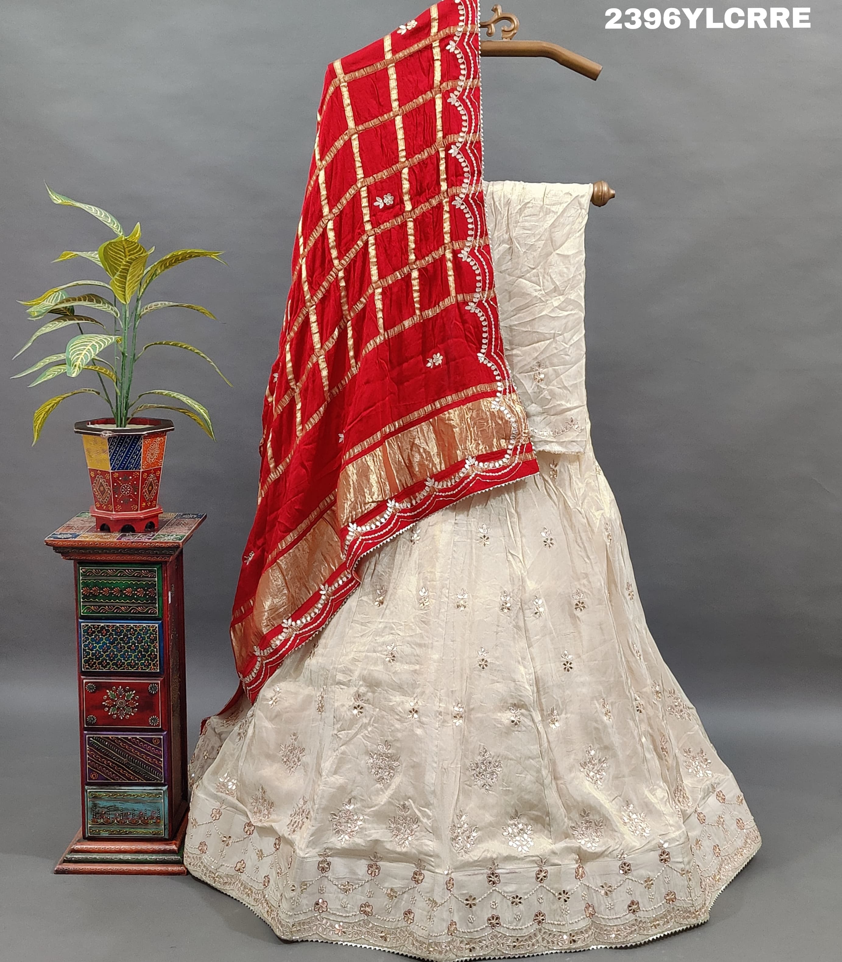 A cream-colored Lehenga with red and gold Gota patti Work