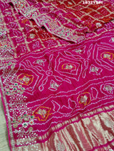 A pink saree with bandhani and gotapatti work, including intricate patterns and embellishments.