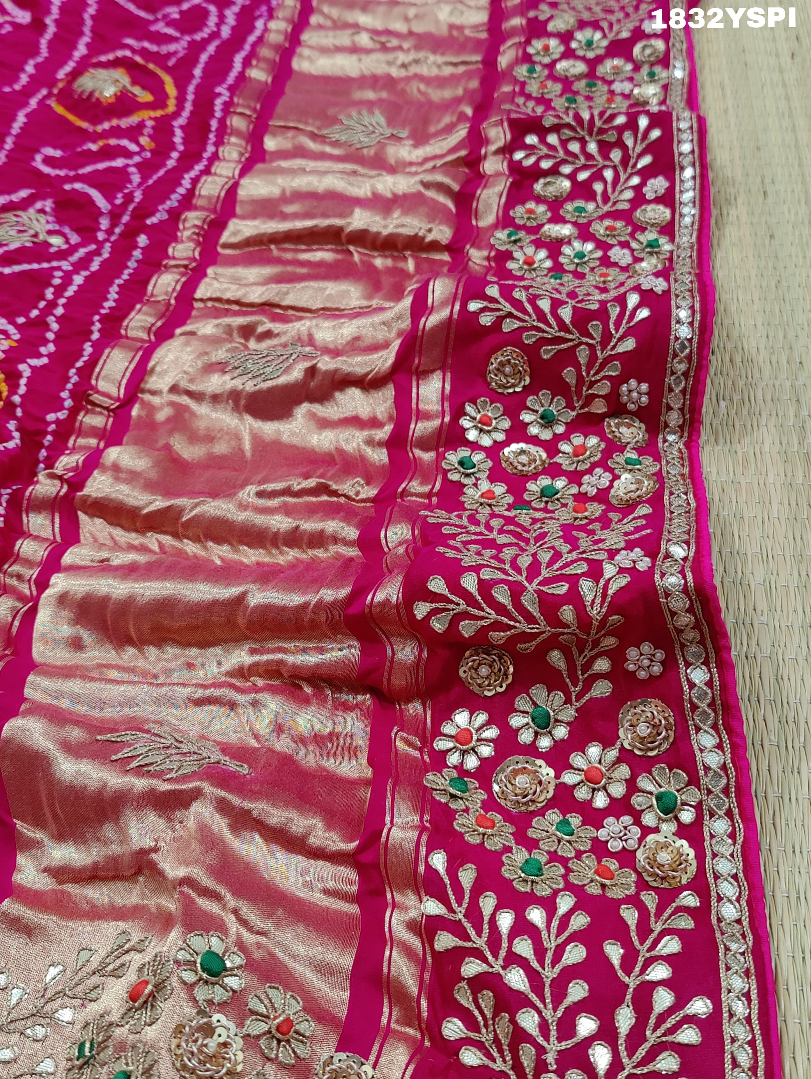 A pink saree with bandhani and gotapatti work, including intricate patterns and embellishments.