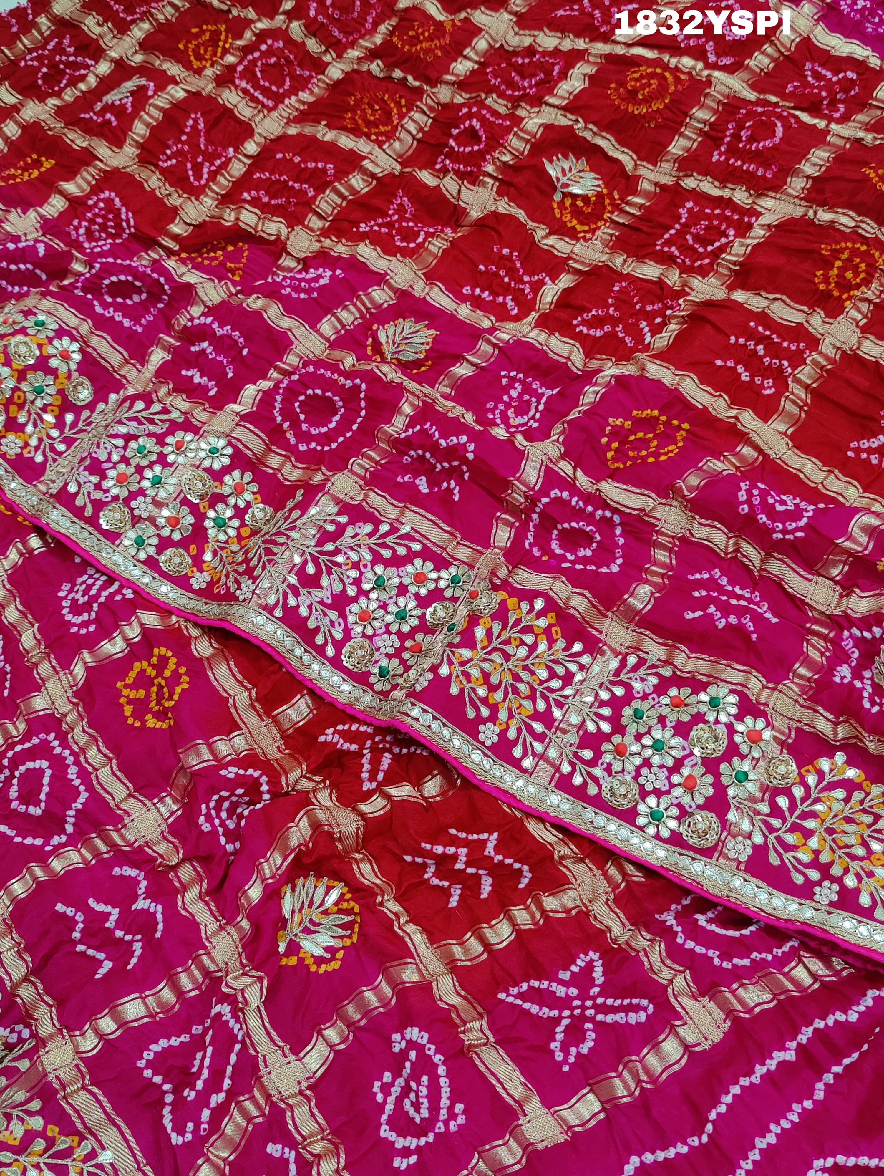 A pink saree with bandhani and gotapatti work, including intricate patterns and embellishments.