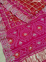 A pink saree with bandhani and gotapatti work, including intricate patterns and embellishments.