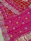 A pink saree with bandhani and gotapatti work, including intricate patterns and embellishments.