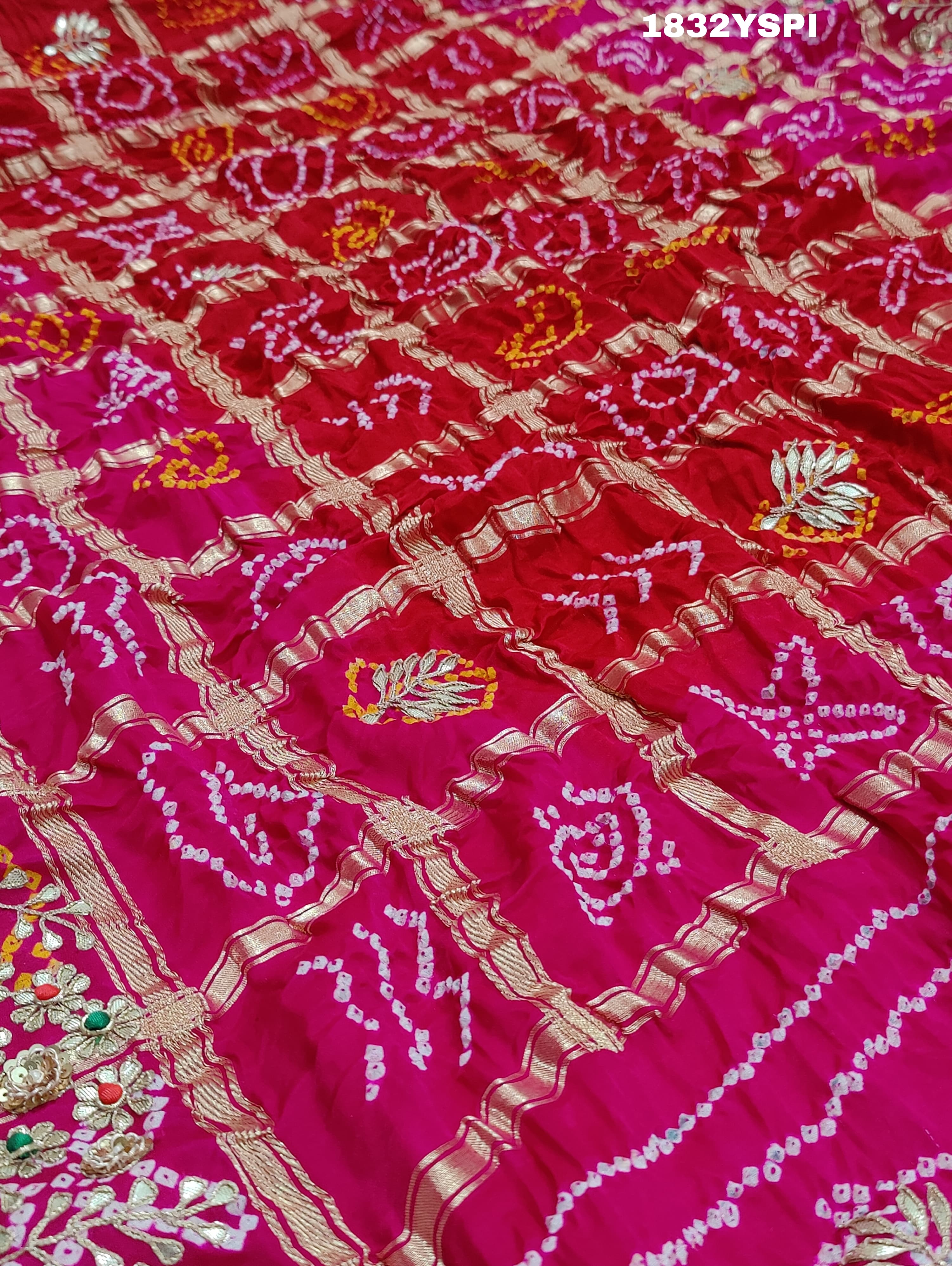 A pink saree with bandhani and gotapatti work, including intricate patterns and embellishments.