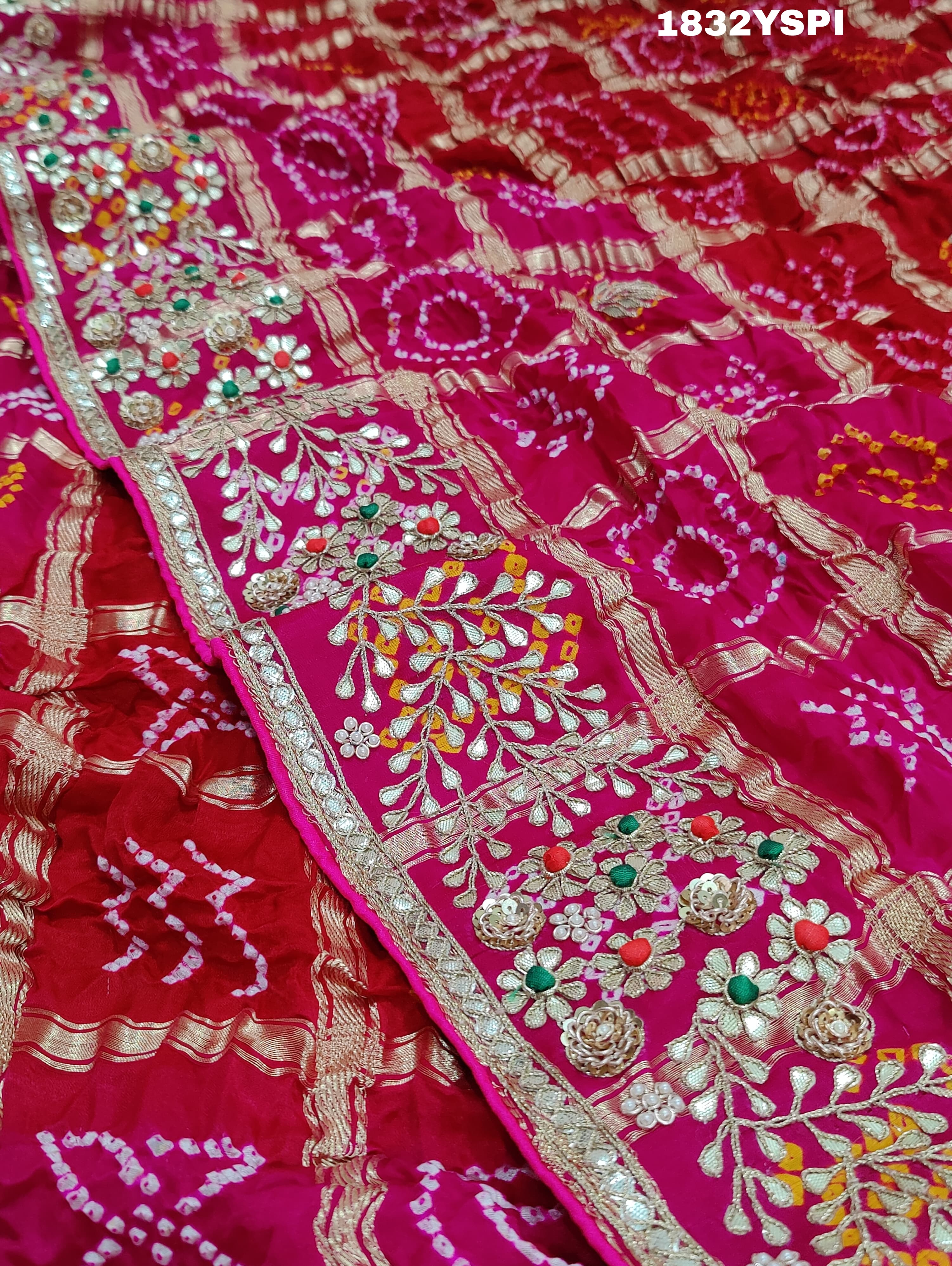 A pink saree with bandhani and gotapatti work, including intricate patterns and embellishments.