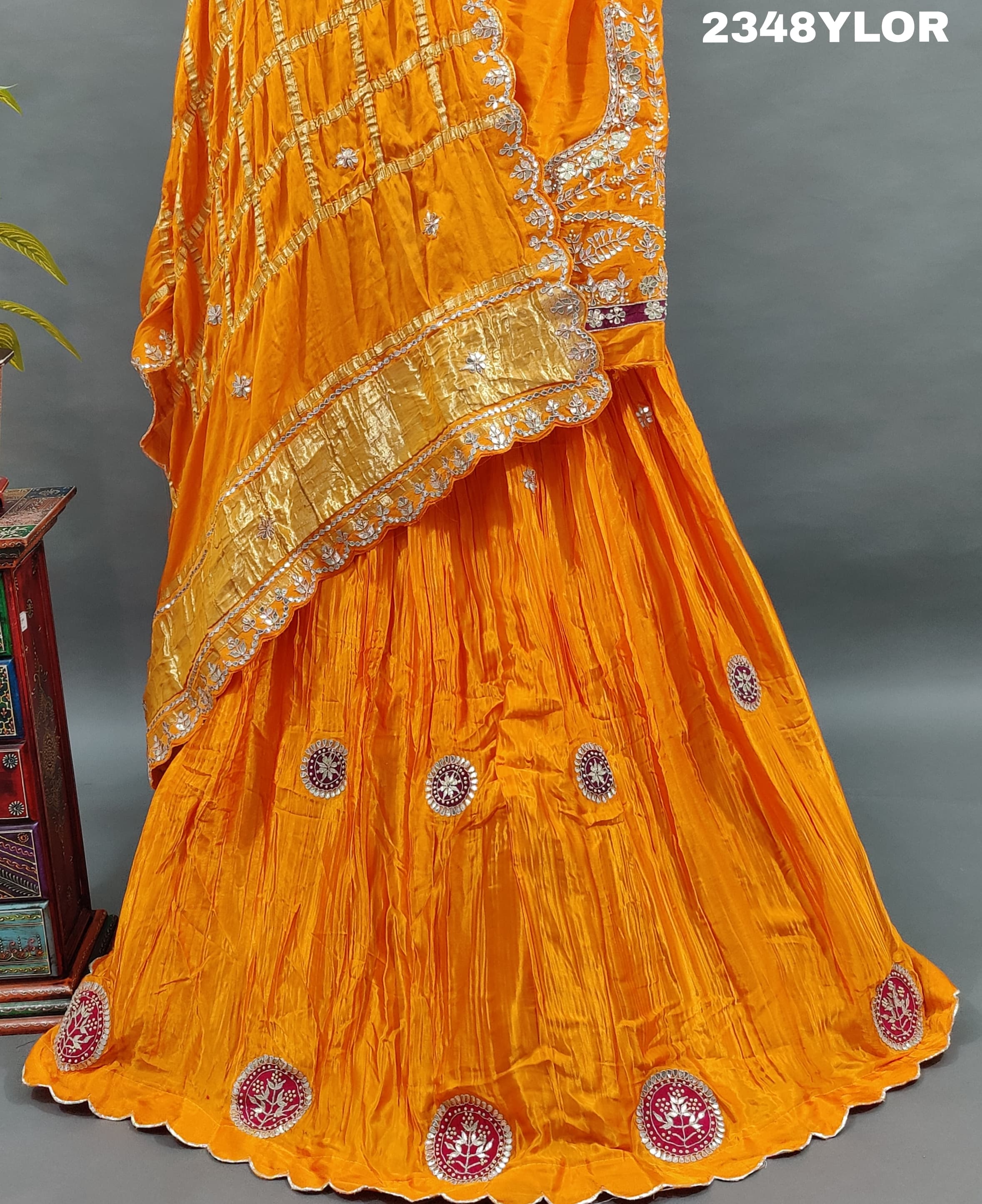 An elegant orange Gaji silk lehenga with Bollywood style Gotapatti work
