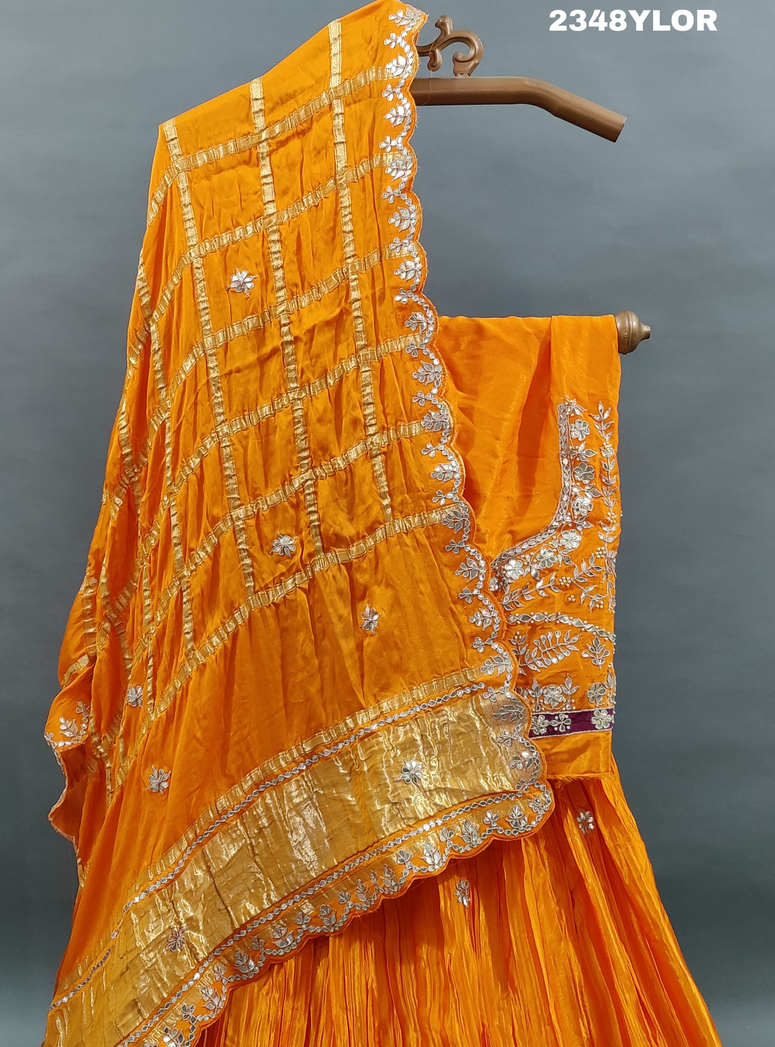 An elegant orange Gaji silk lehenga with Bollywood style Gotapatti work