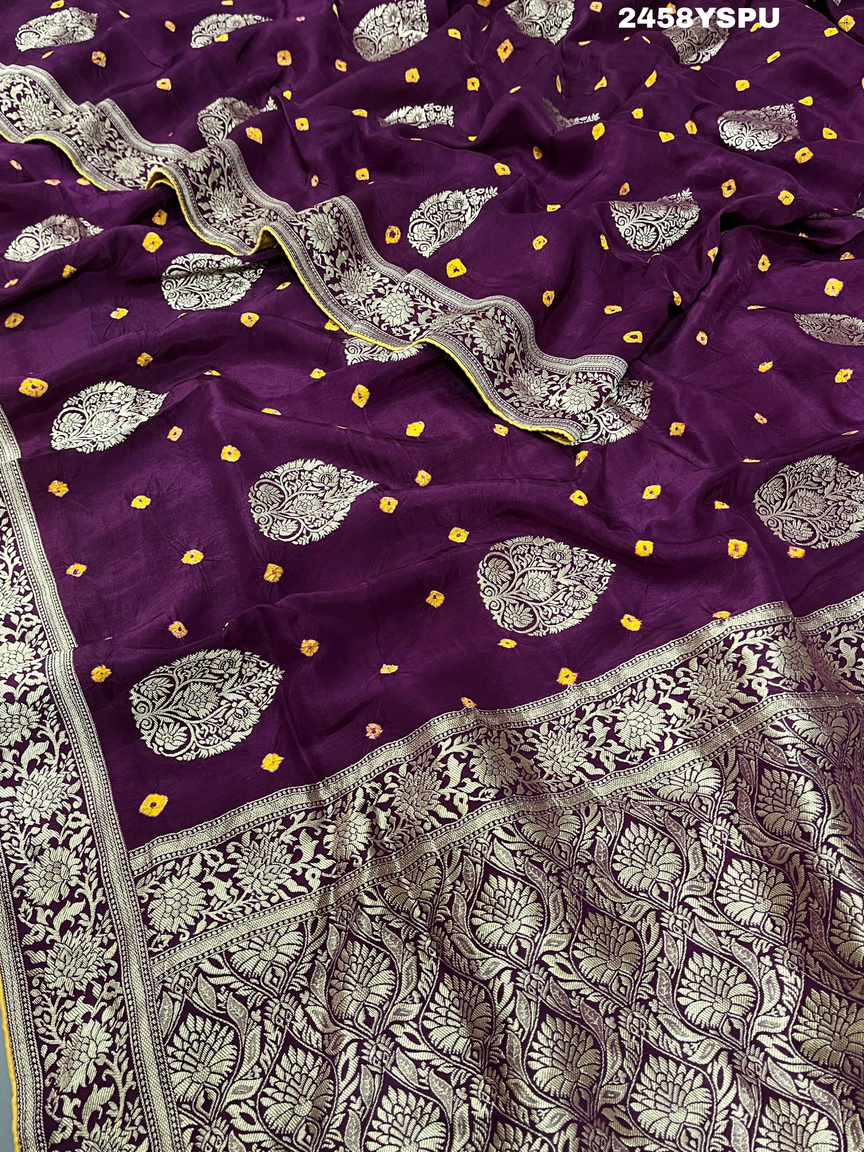 A purple Dola silk saree with detailed Zari weaving work and a Banarasi style pattern, including a wide border with similar ornate design.