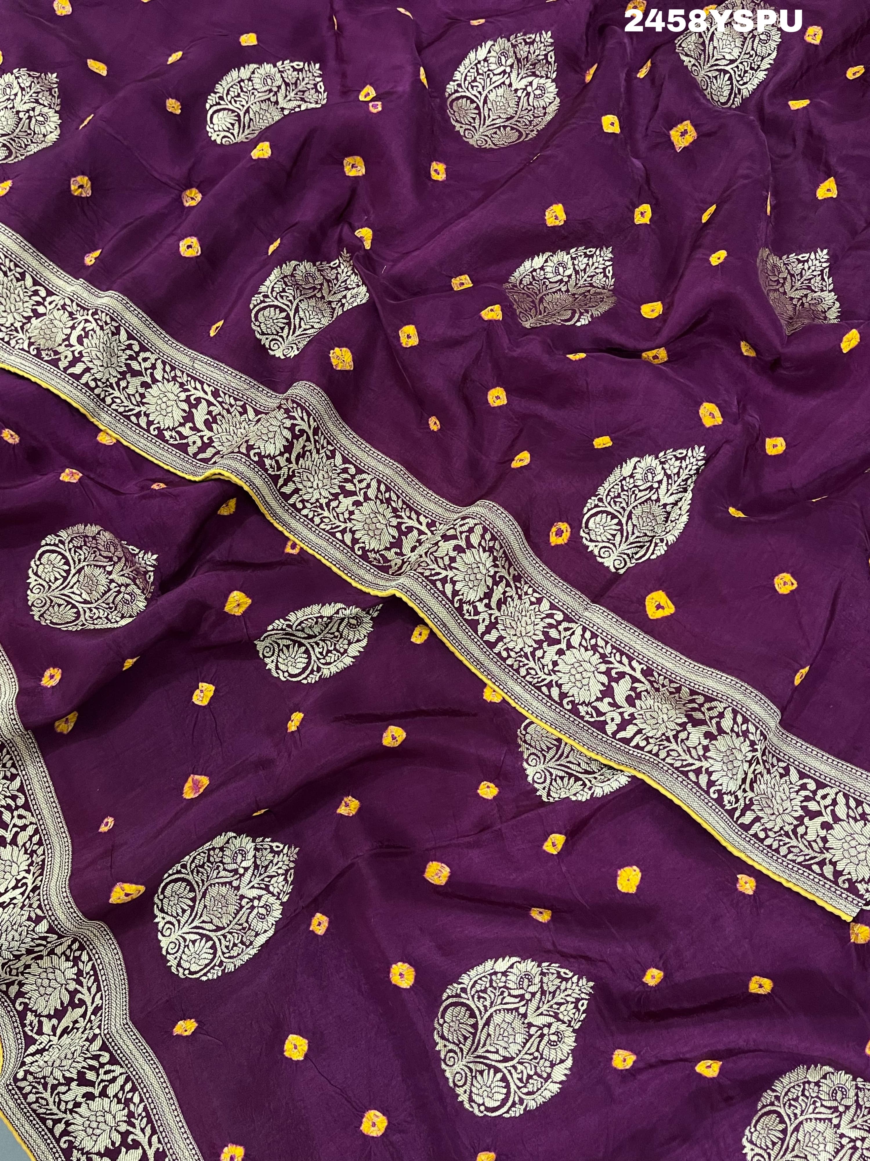 A purple Dola silk saree with detailed Zari weaving work and a Banarasi style pattern, including a wide border with similar ornate design.