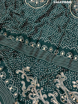 A green modal silk saree with bandhani style patterns and gotapatti work