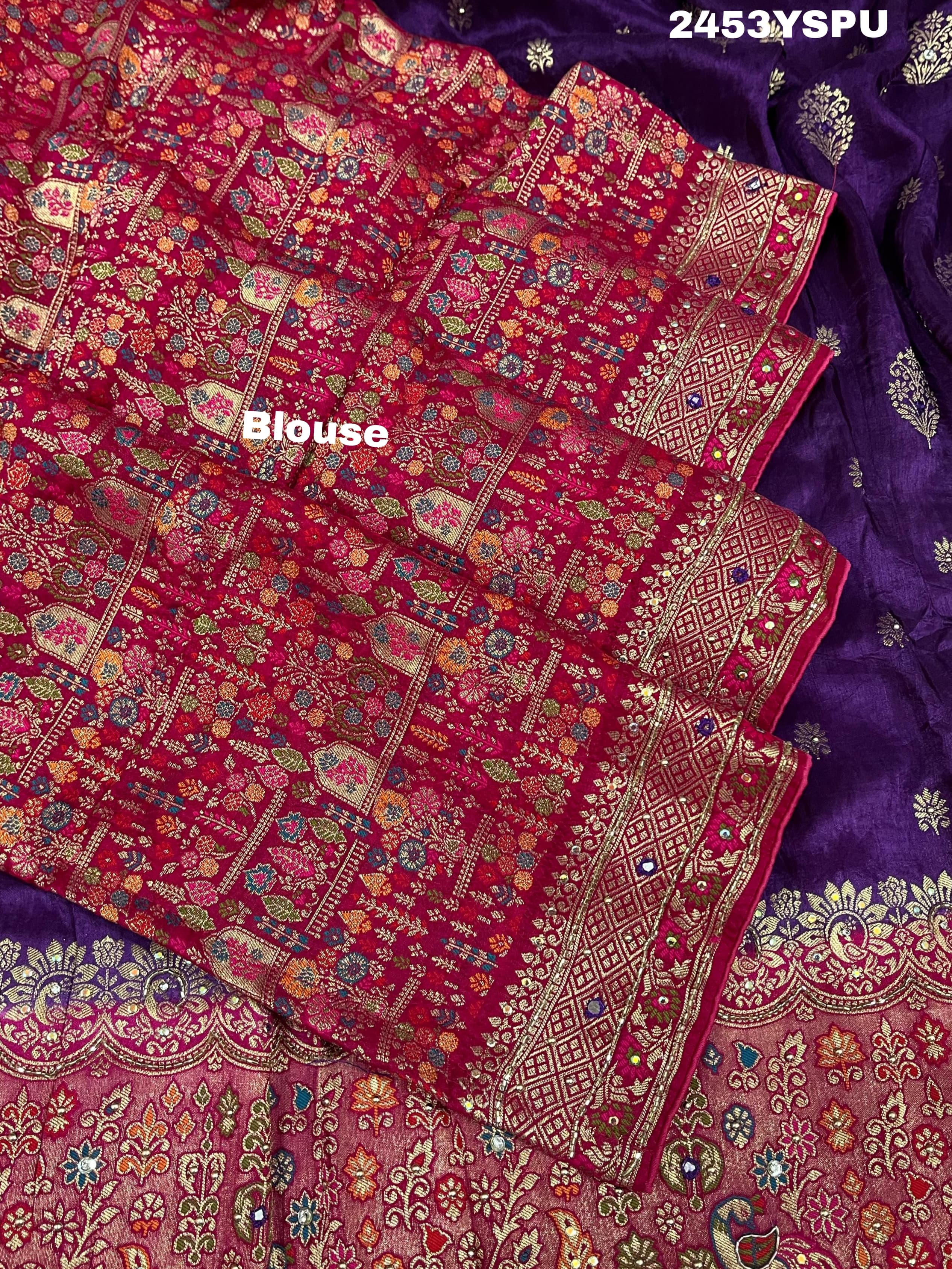 A purple and red Dola silk Banarasi saree with cutdana work, captured with a floral design at the border.