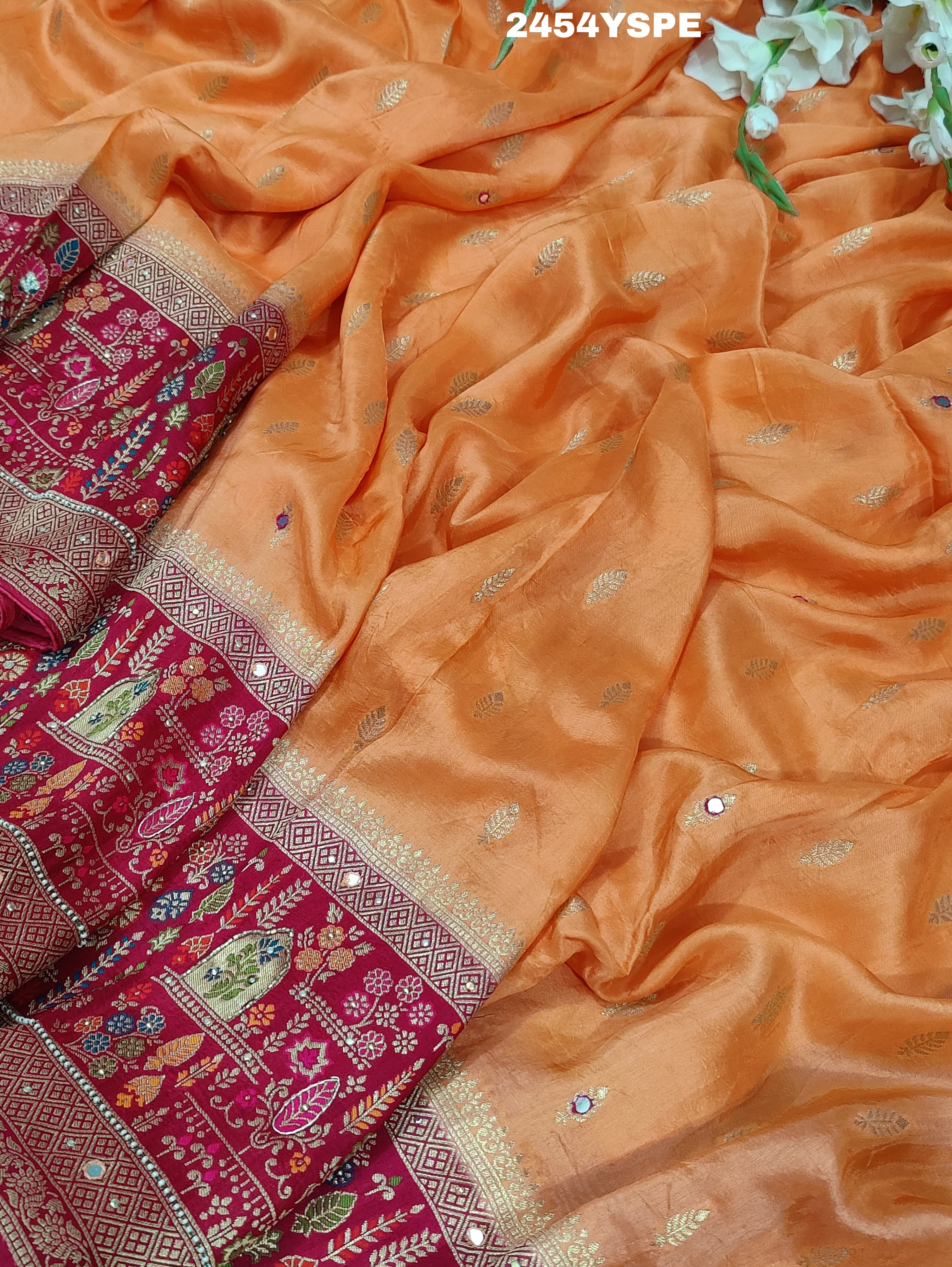 A Banarasi style saree with peach color and cutdana work, accompanied by a red and gold patterned border.
