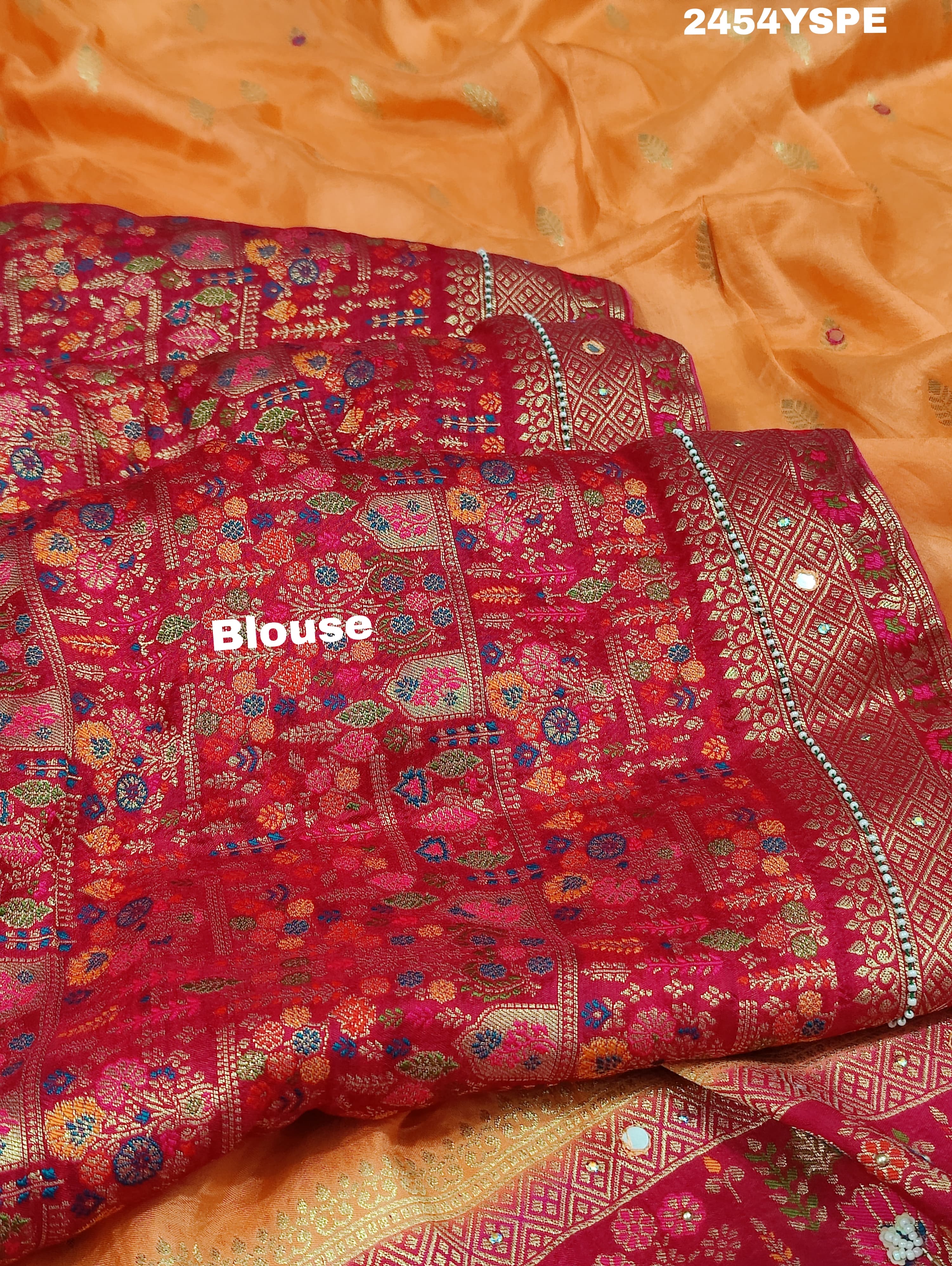A Banarasi style saree with peach color and cutdana work, accompanied by a red and gold patterned border.