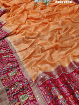 A Banarasi style saree with peach color and cutdana work, accompanied by a red and gold patterned border.
