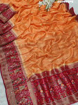 A Banarasi style saree with peach color and cutdana work, accompanied by a red and gold patterned border.
