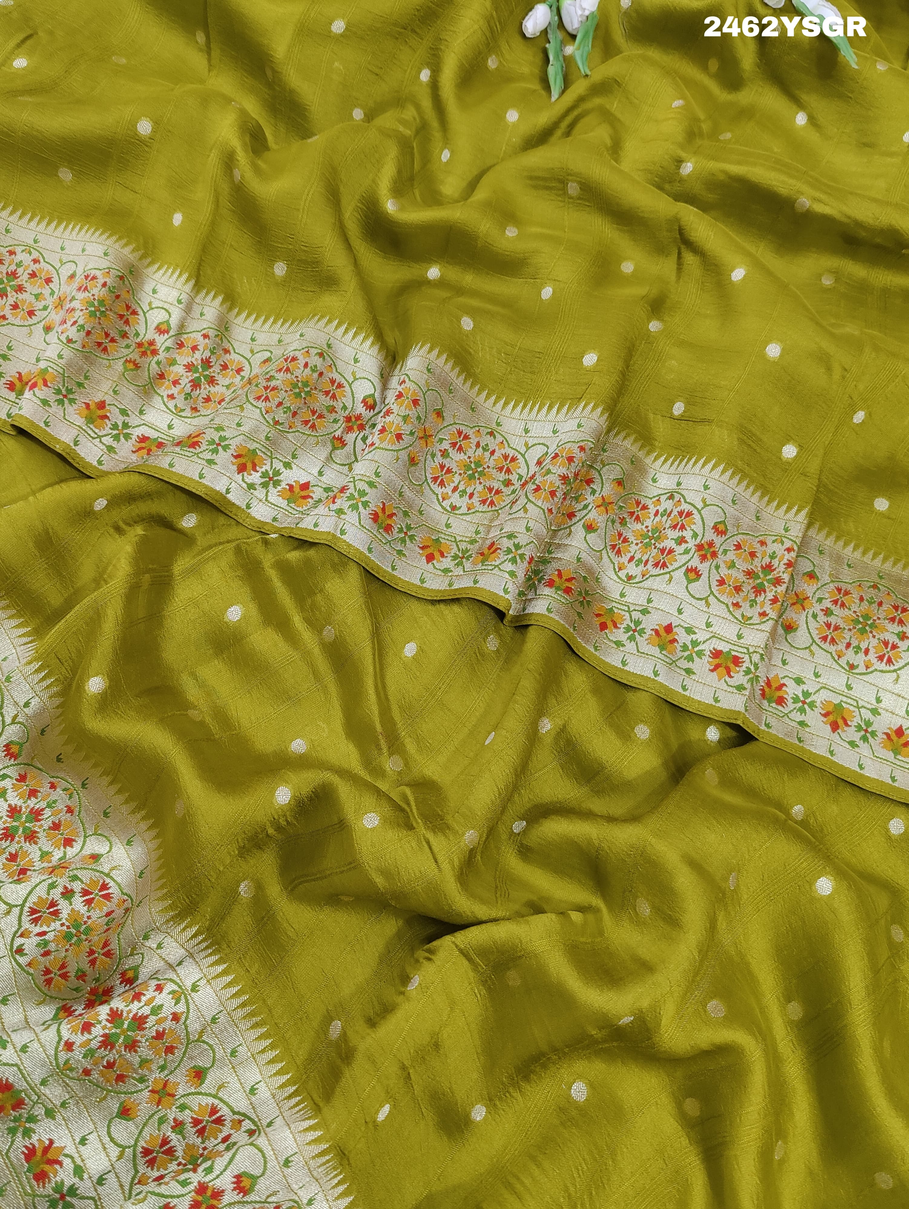 A green Banarasi silk saree with zari weaving and floral embellishments,