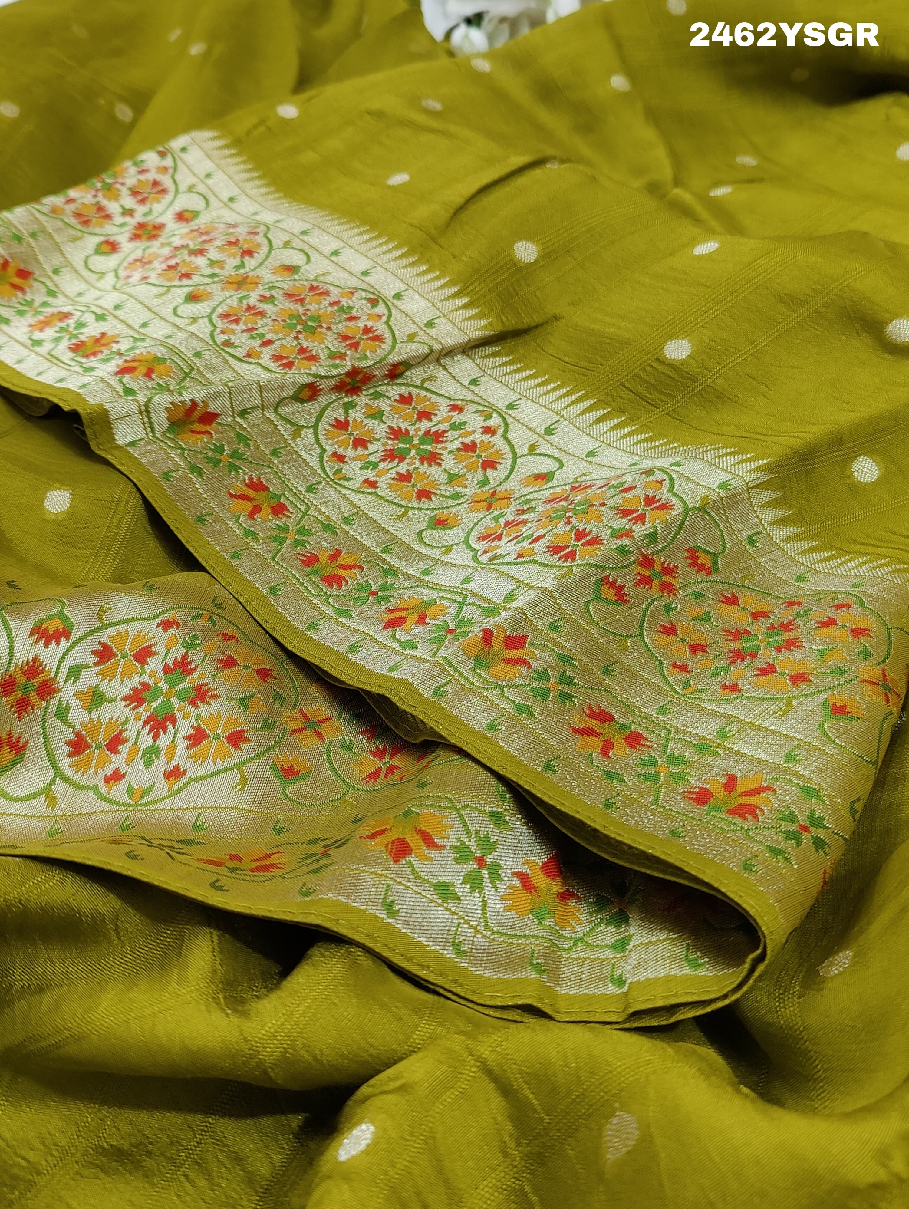 A green Banarasi silk saree with zari weaving and floral embellishments,
