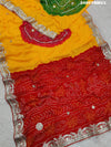 A saree with bandhani style patterns in orange and red colors, featuring detailed gotapatti work.