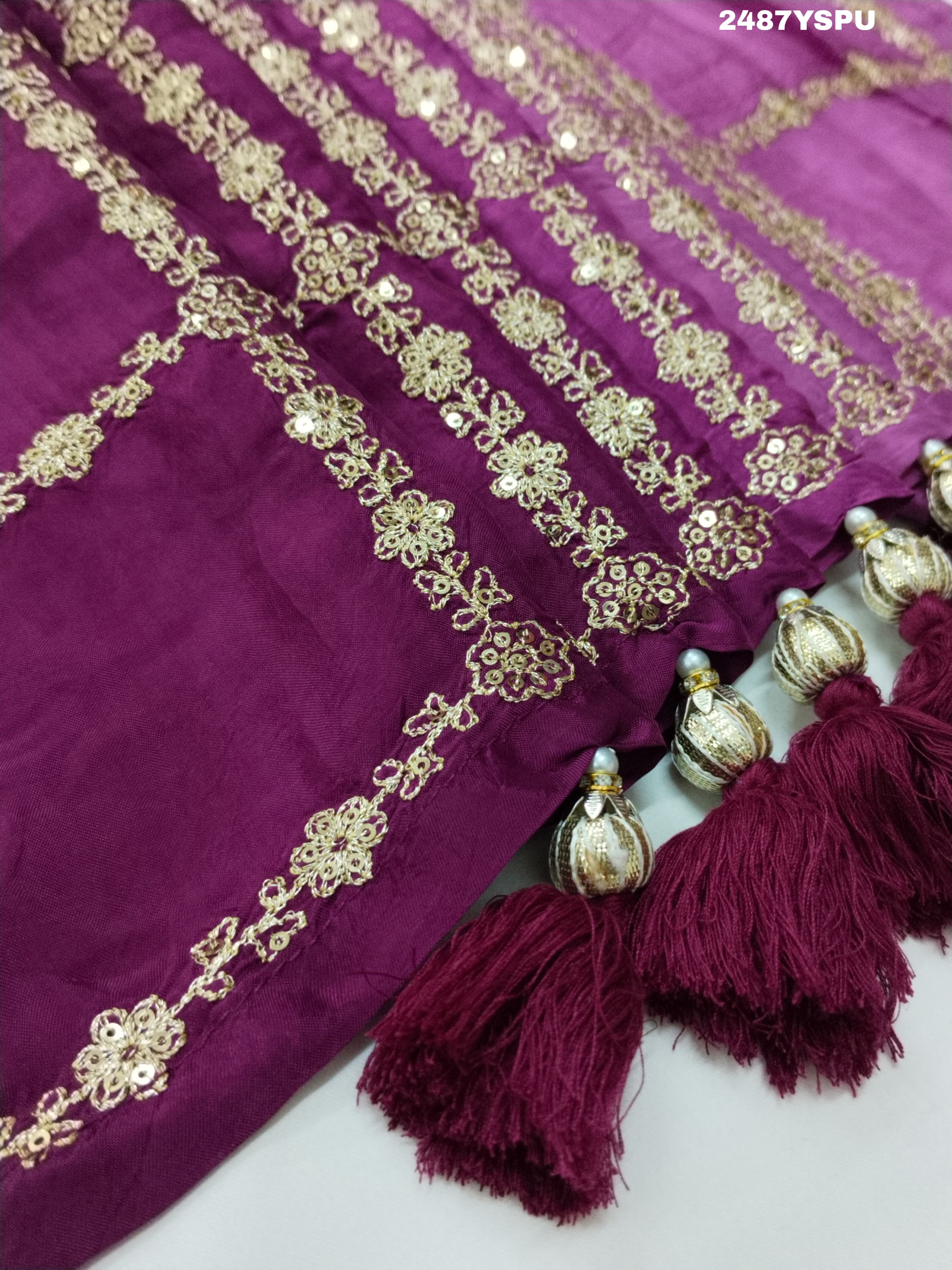 A purple Bollywood style silk saree with geometric pattern and pittan work