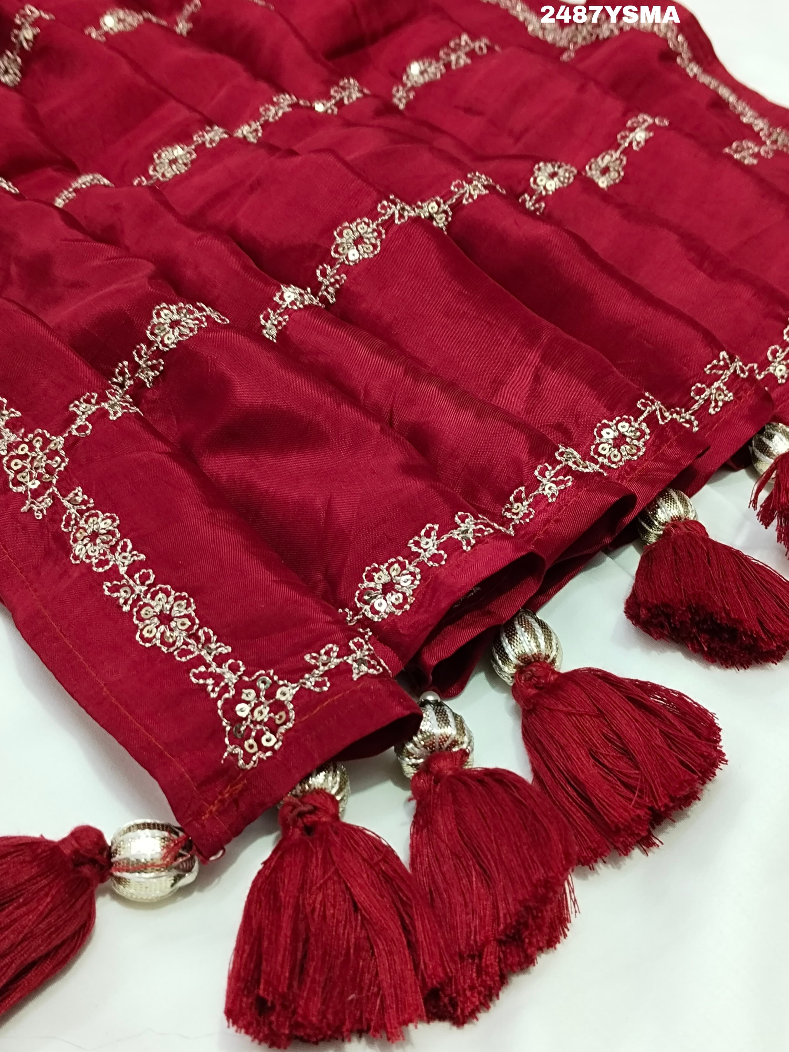 A maroon saree with geometric pattern and pittan work
