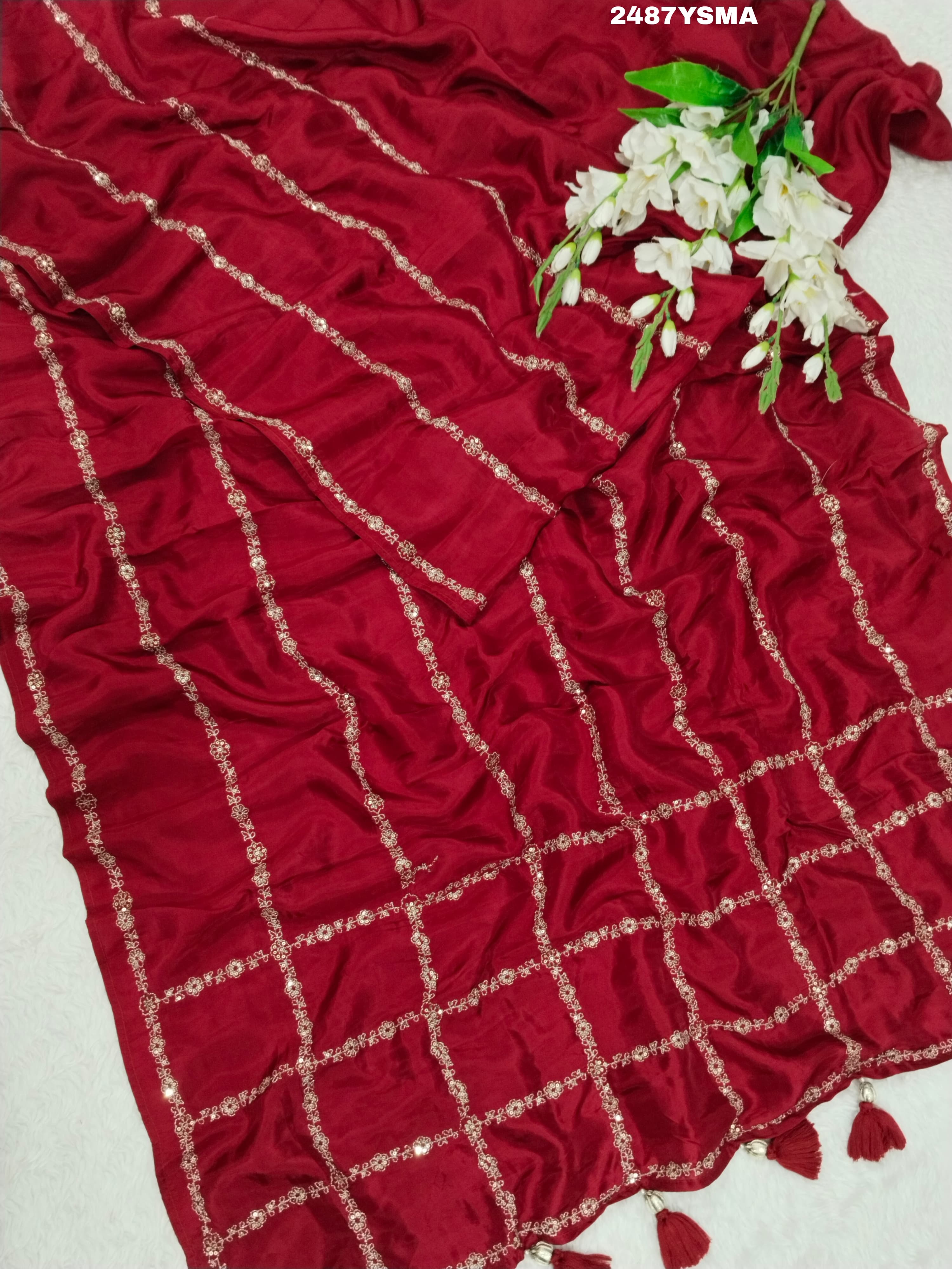 A maroon saree with geometric pattern and pittan work