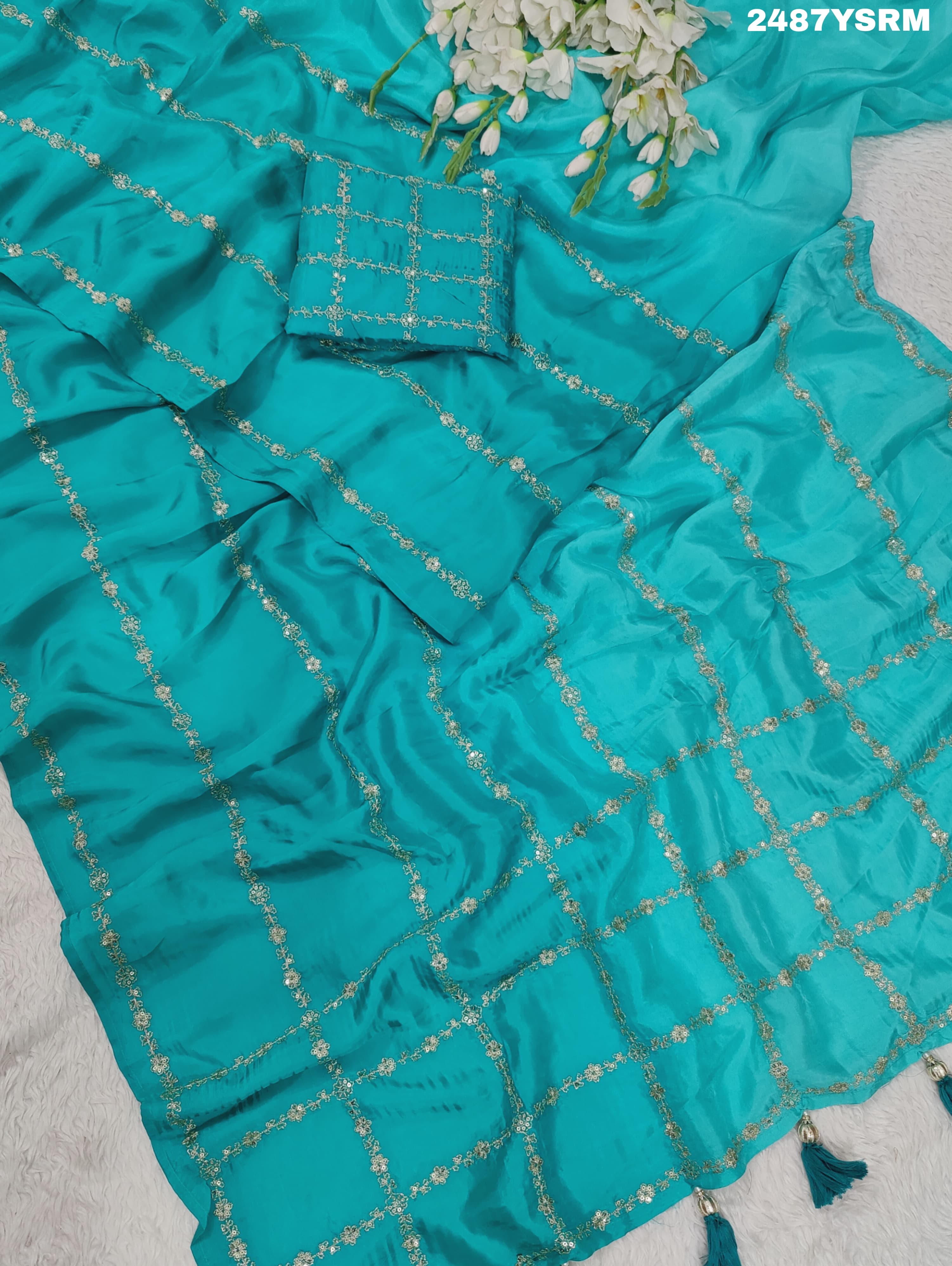 A sea green color saree with geometric pattern and pittan work